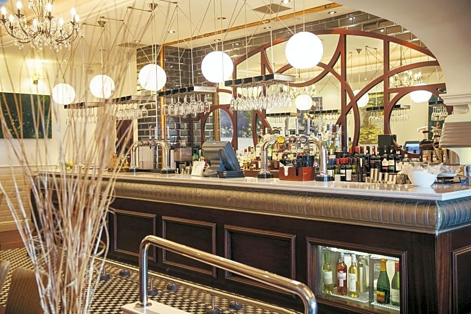 Elegant bar interior with hanging glass globes, mirrored back, and bottles on display