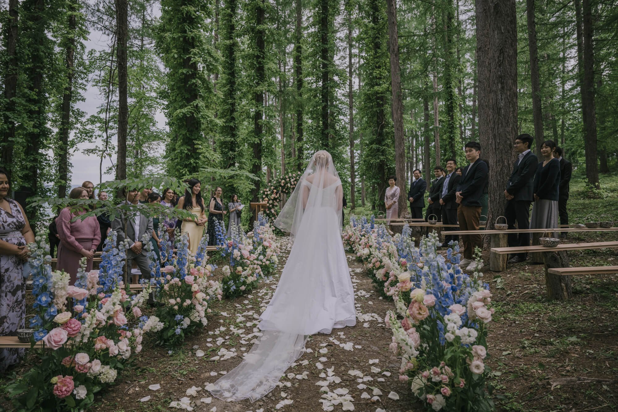 Bride in long embroidered veil walking down aisle