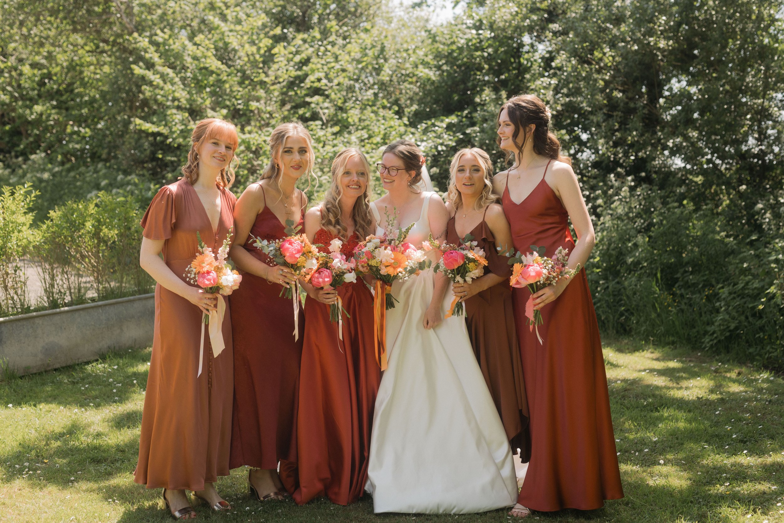  Bride with her bridesmaids in burnt orange dresses 