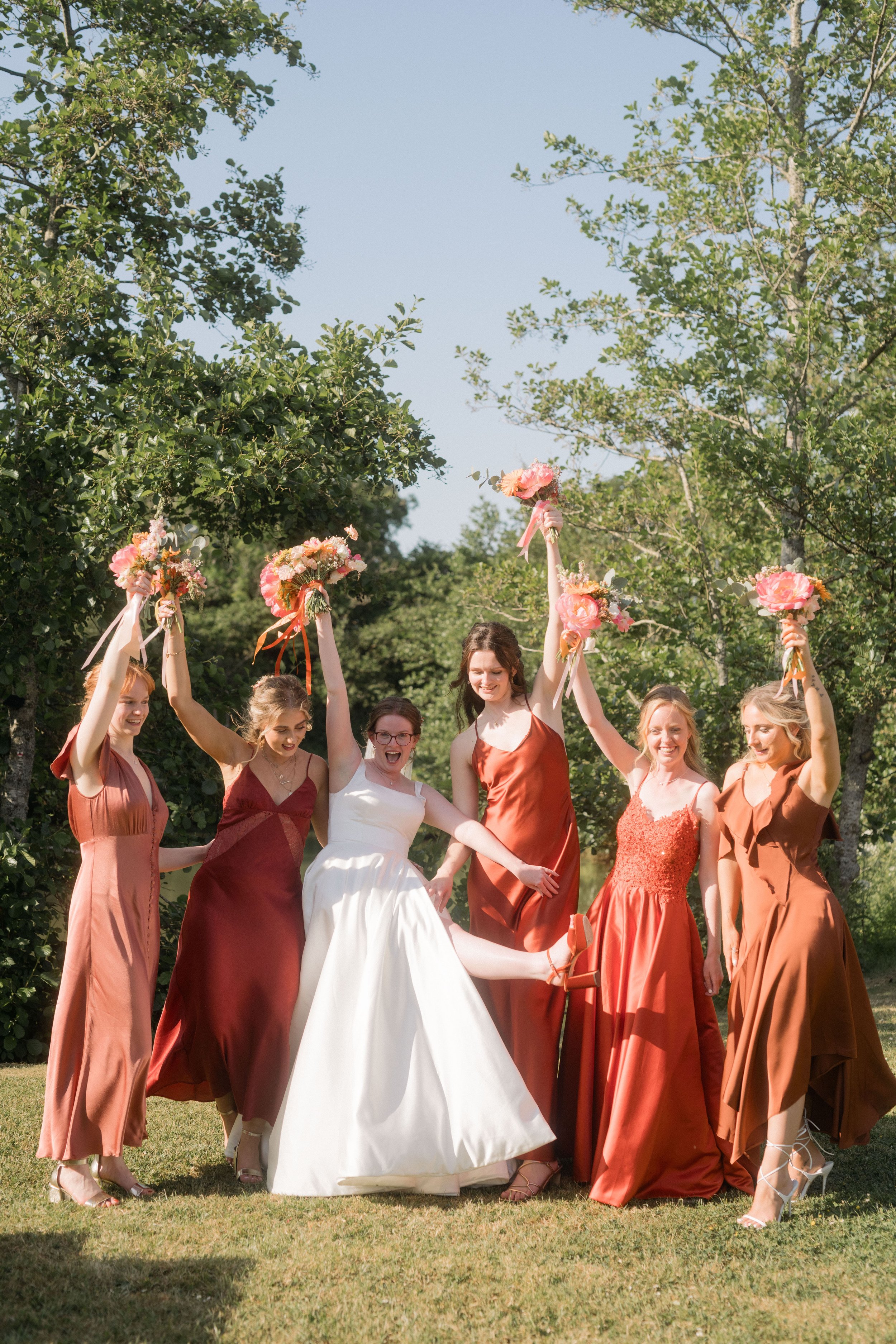  Bride having fun with her bridesmaid in orange dresses 