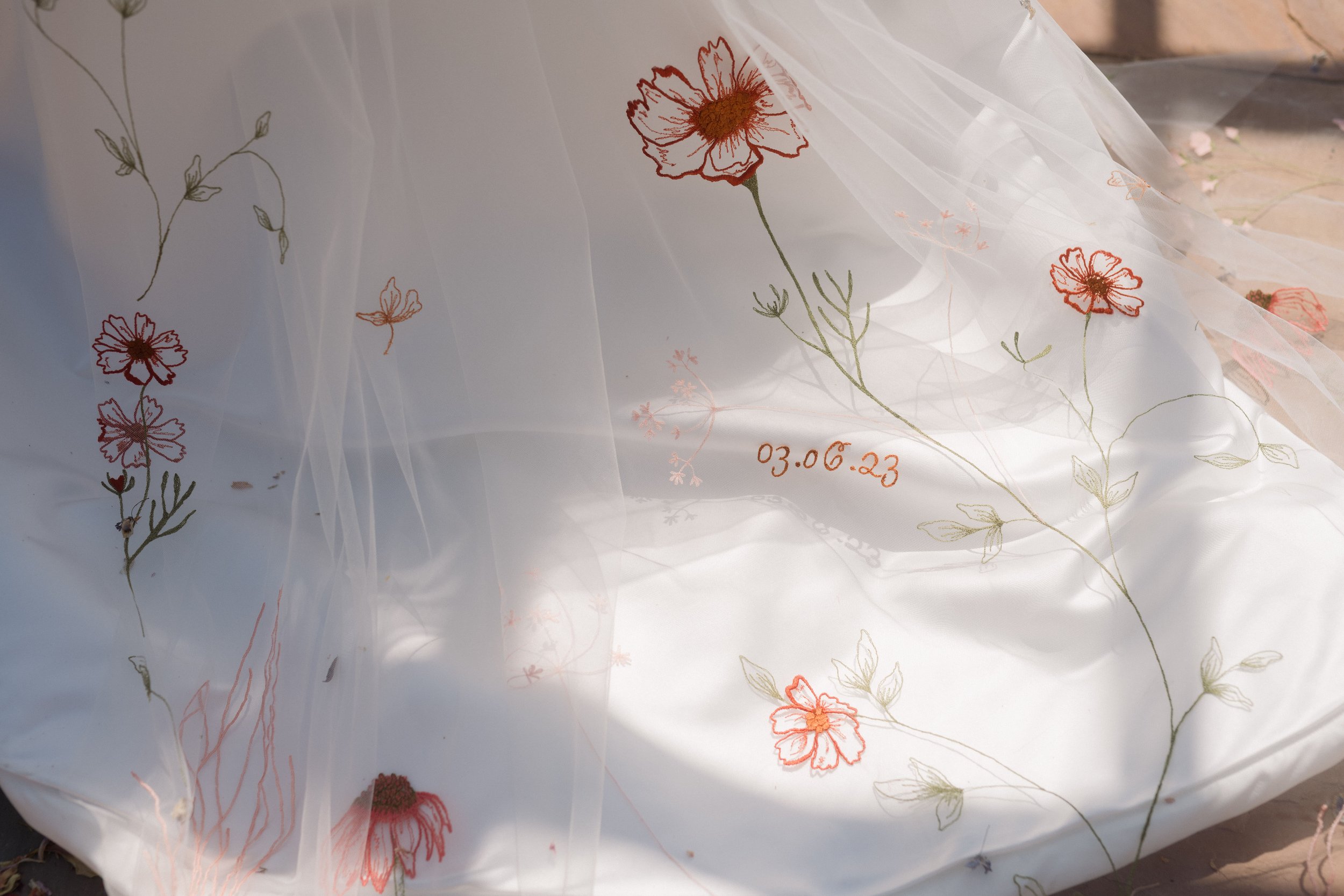 Embroidered veil against train of wedding dress