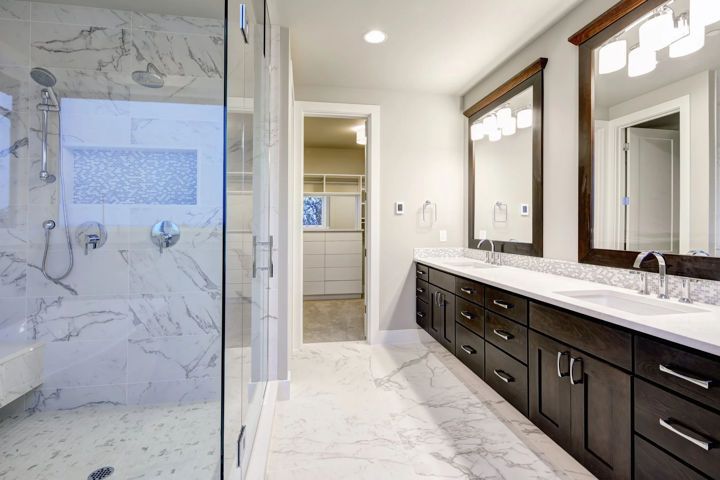 Bright and airy master bathroom features White Modern Double Vanity With Rich Brown Cabinets and marble walk-in shower. Denver, Littleton, Centennial, Parker Colorado