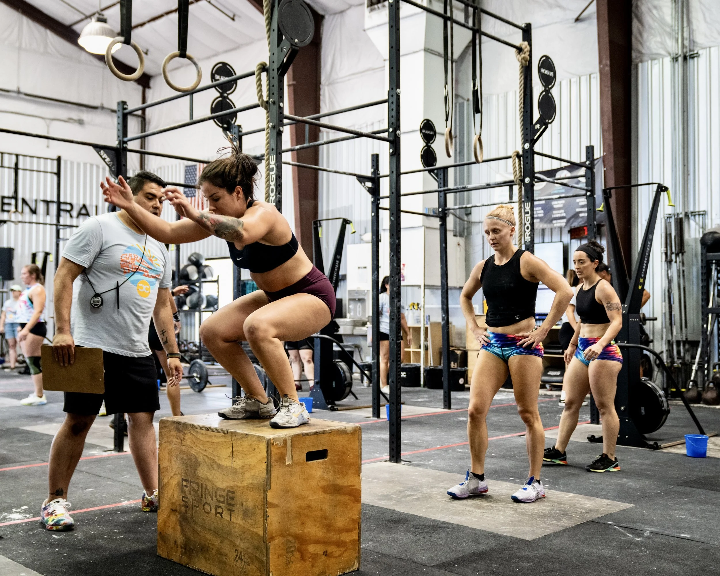Women Box Jumping at a Crossfit Competition