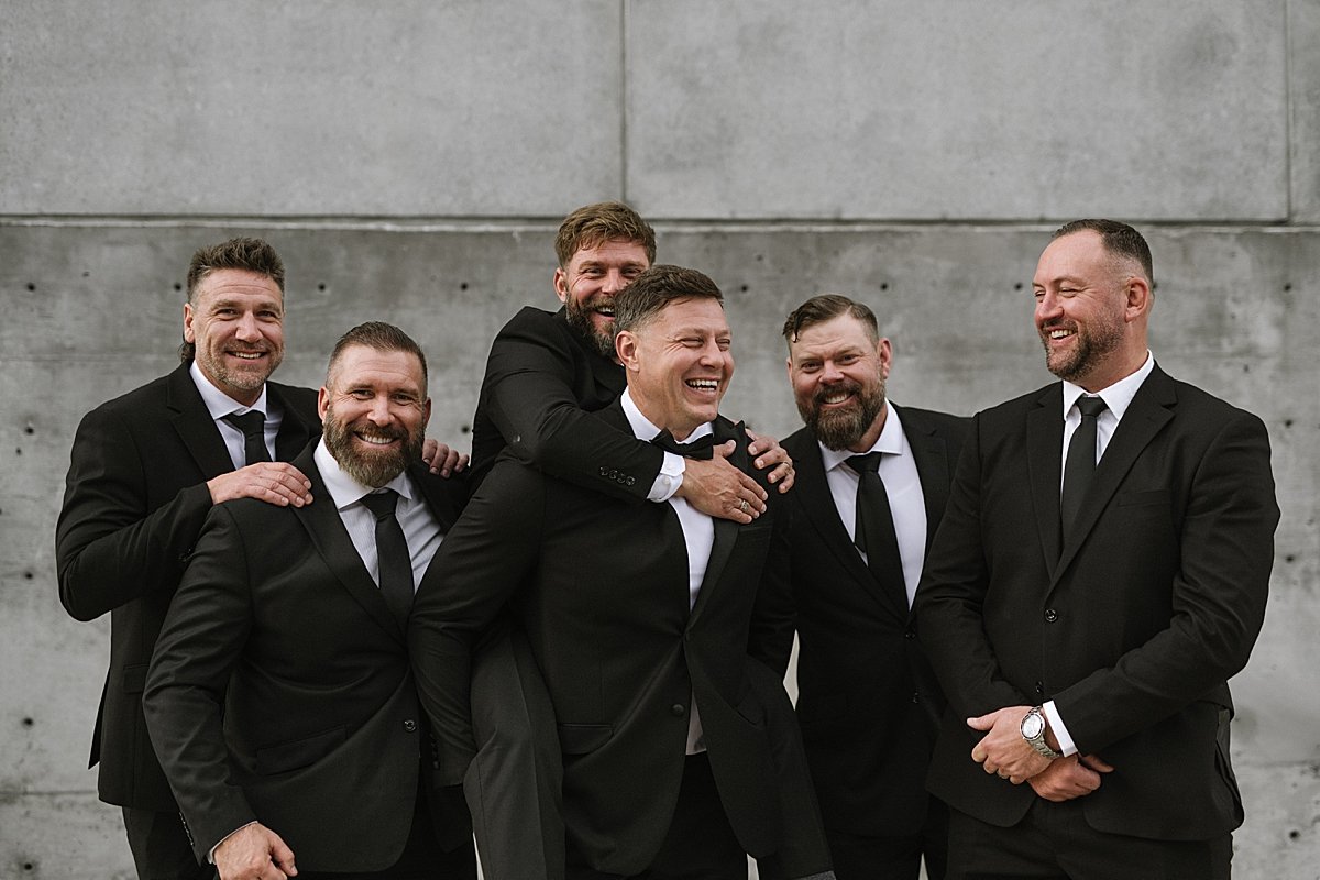 groomsmen joking around and laughing during creative portraits