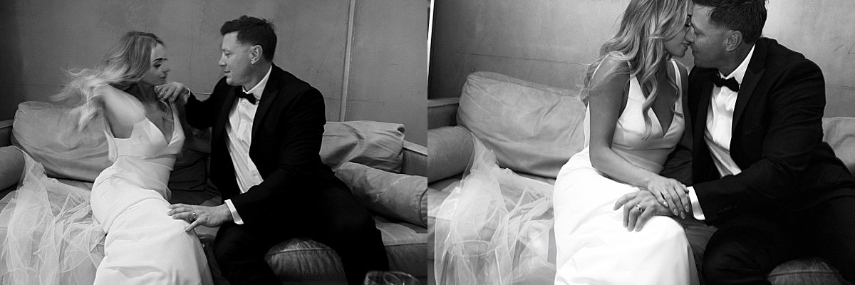 Bride and groom relaxing on a couch with wine glasses during their stylish Kamloops wedding reception at the Delta Hotel