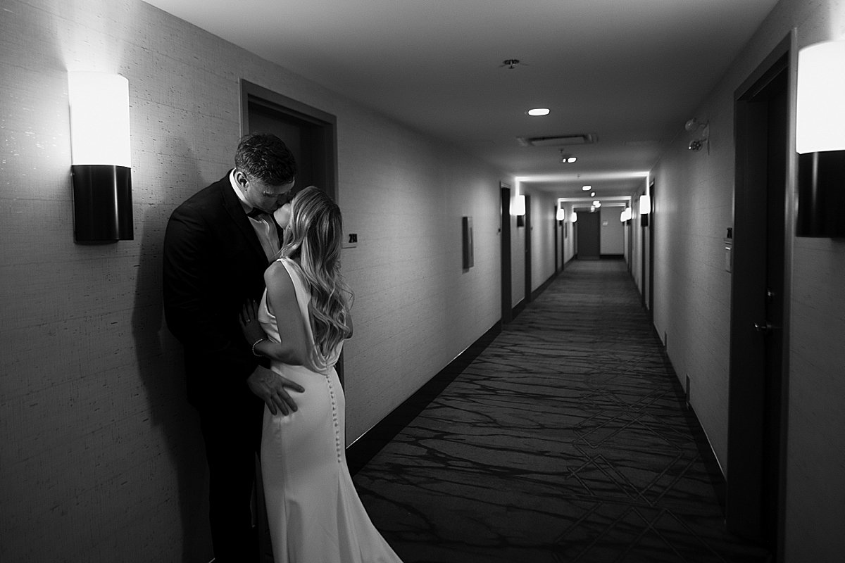 wedding couple sneaking off for intimate photos in hallway on their wedding night in kamloops
