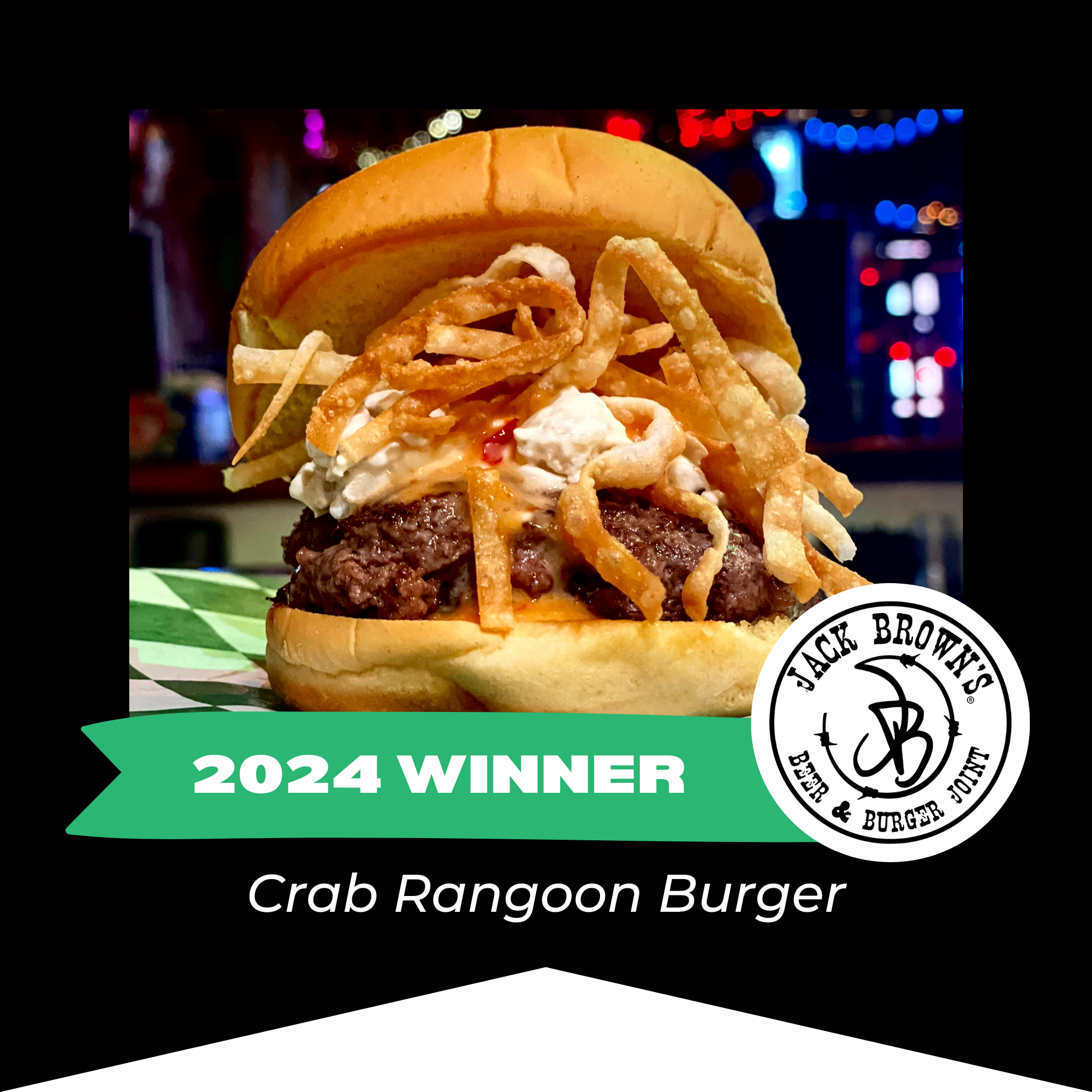 Close-up of a crab Rangoon burger with fried onions, cream cheese, and sauce in a bun, with a background of colorful, blurred lights. Includes award banner for 2024 winner and Jack Browns logo.