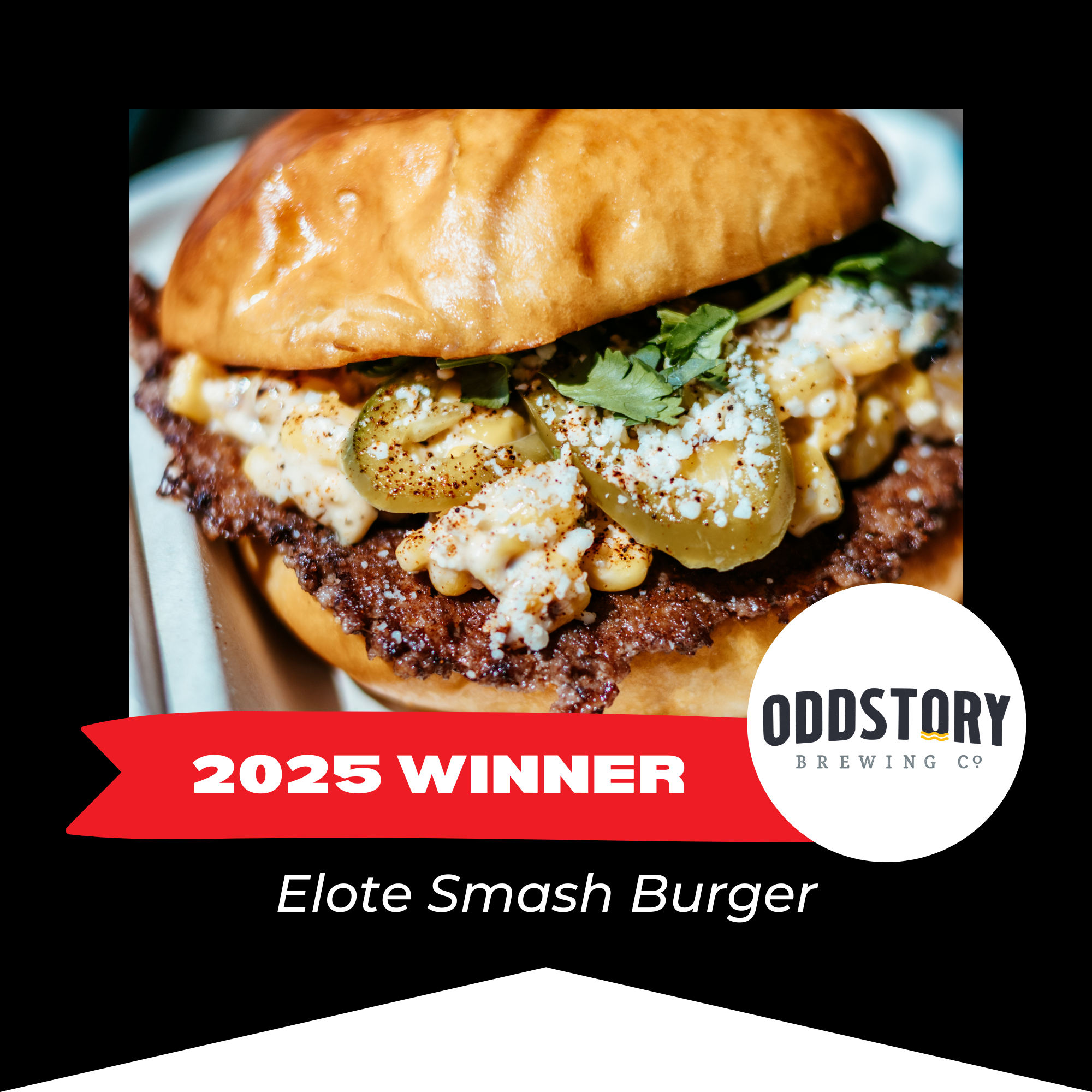 Close-up of an Elote Smash Burger with a toasted bun, seasoned ground beef patty, jalapeno slices, crumbled cheese, cilantro, and a creamy topping, with a black background and a red banner indicating '2025 WINNER' from Oddstory Brewing Co.