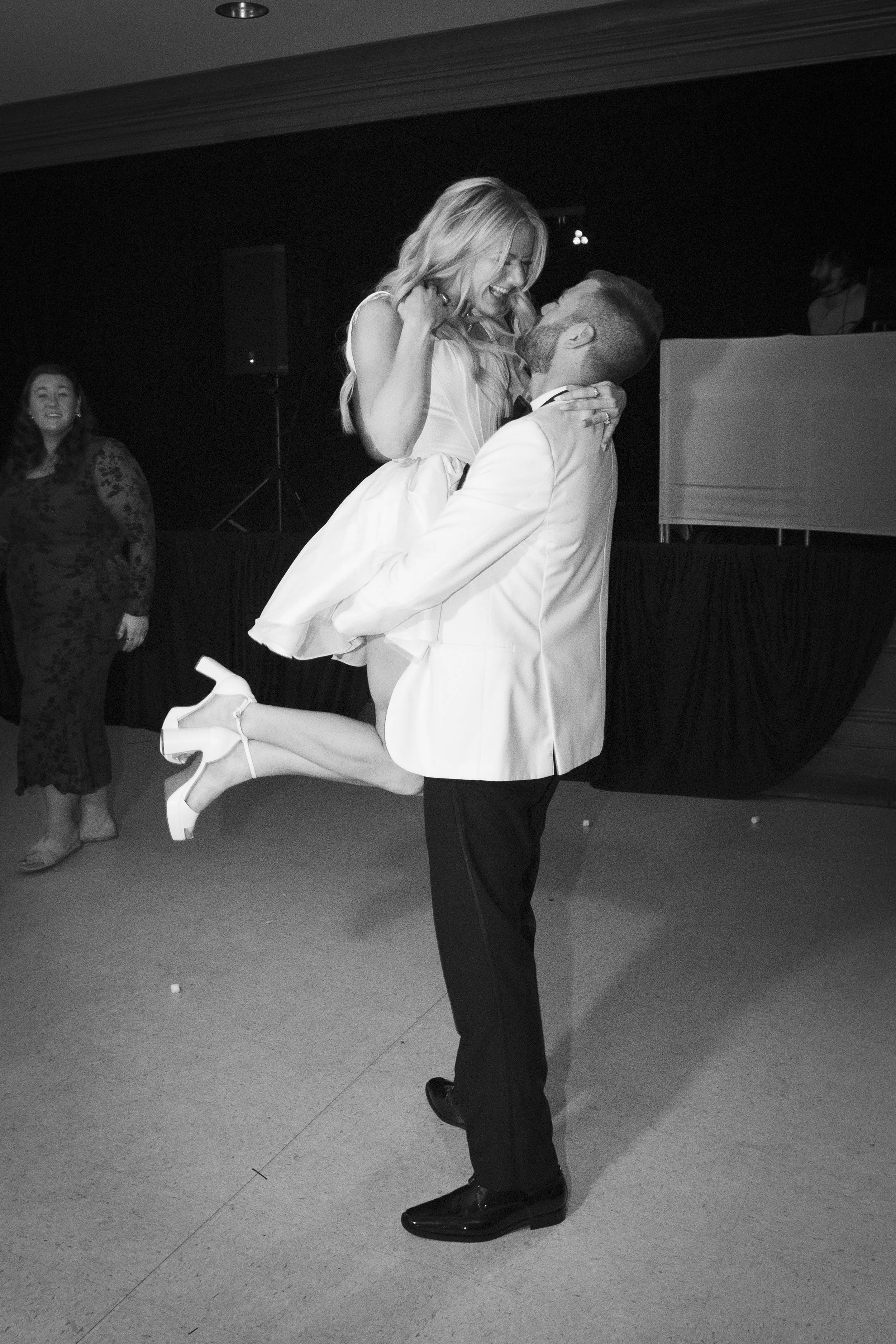 black and white image of Serbian wedding couple spinning on the dance floor smiling