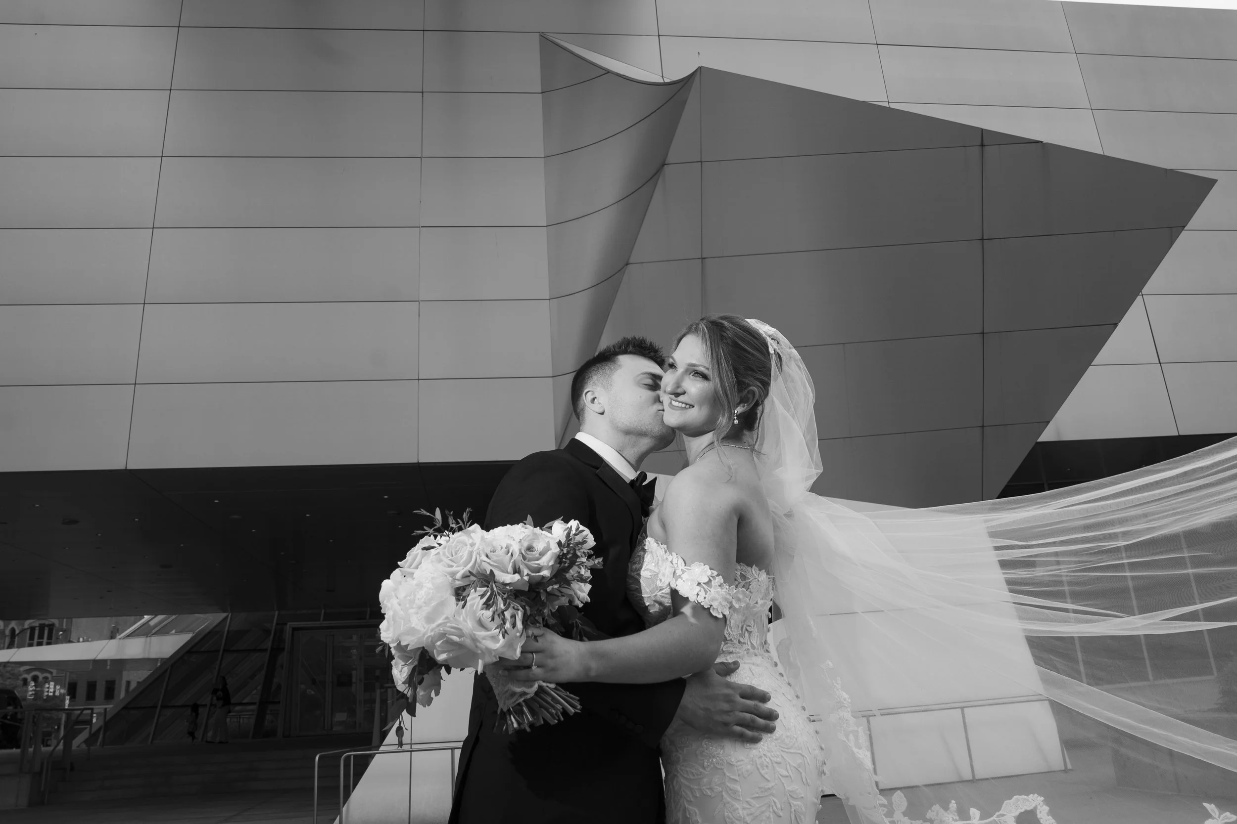Black and white photo of Bride and Groom in front of Akron Art Museum off camera lighting