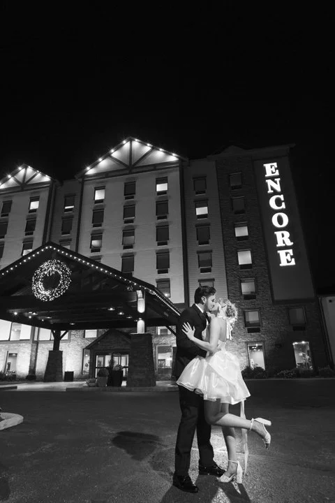 Newlywed couple kissing outside the Encore hotel entrance at night