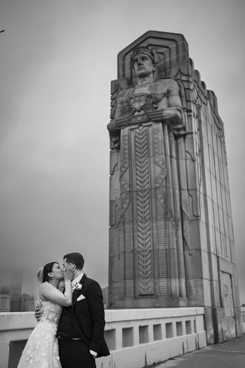 Bride and groom kissing in front of the Cleveland Guardians Statue
