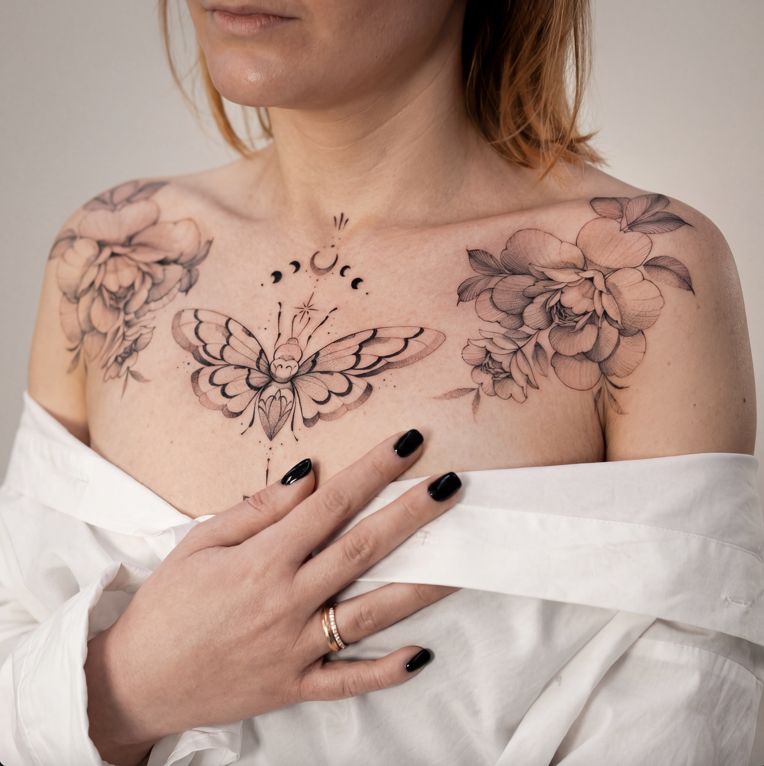 Close-up detail of fine line floral female chest tattoo in black and grey with clean linework, Zen Tattoo Studio