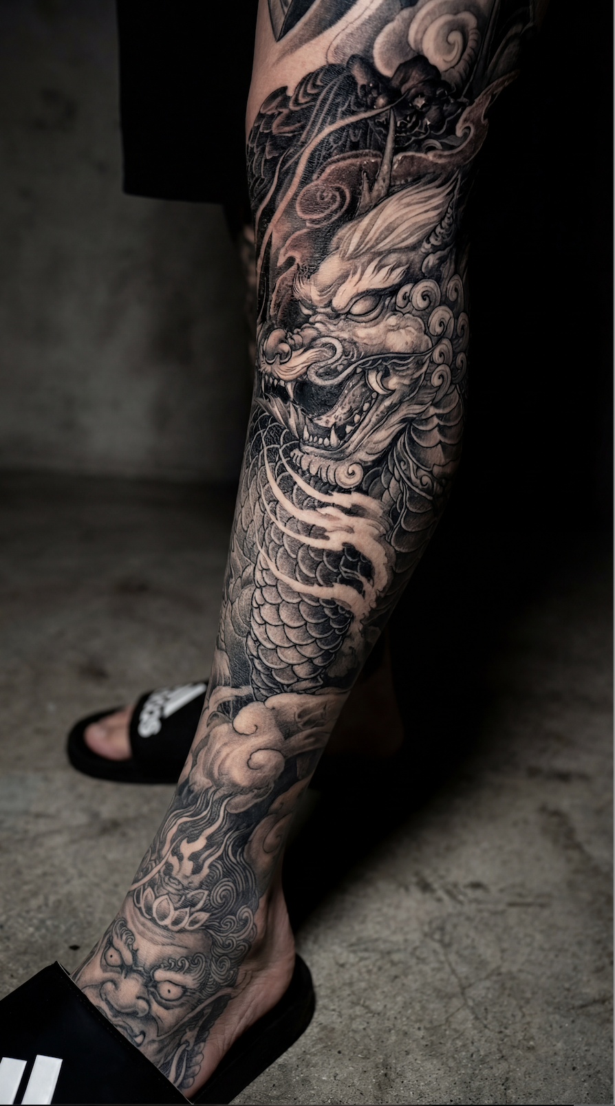 Leg tattoo ideas for guys featuring a Japanese dragon tattoo with flowing scales claws and smoke clouds designed for a thigh or calf leg sleeve