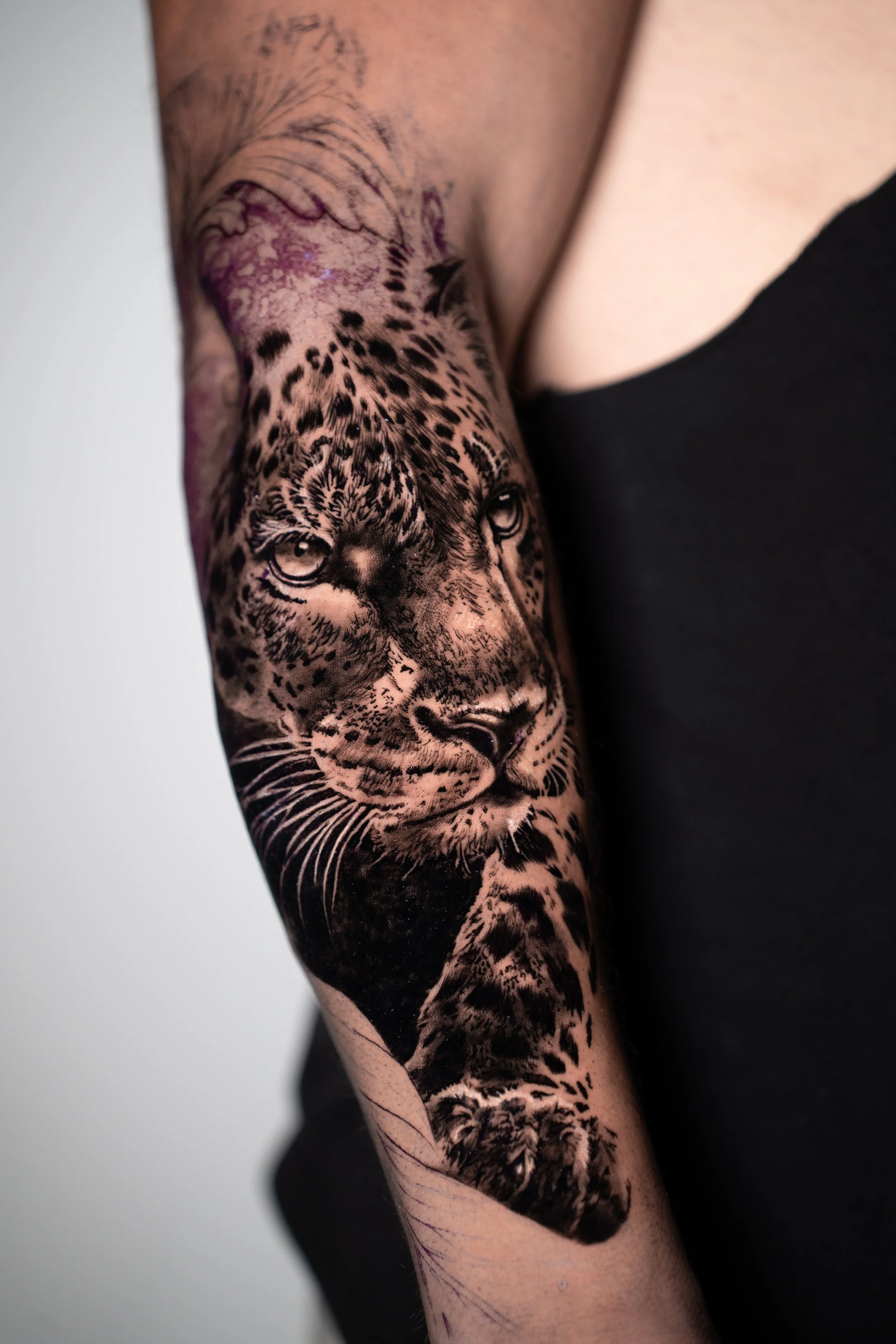 Large scale black and grey leopard tattoo by Luis Fernandez, Zen Tattoo Studio Oakville. Photorealistic animal realism — upper arm sleeve panel with dramatic contrast and fur texture detail.