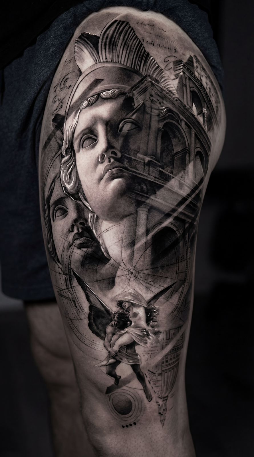 Leg tattoo ideas for guys featuring a black and grey realism thigh tattoo with Greek statue face Roman architecture compass linework and angel figure for a cohesive leg sleeve concept
