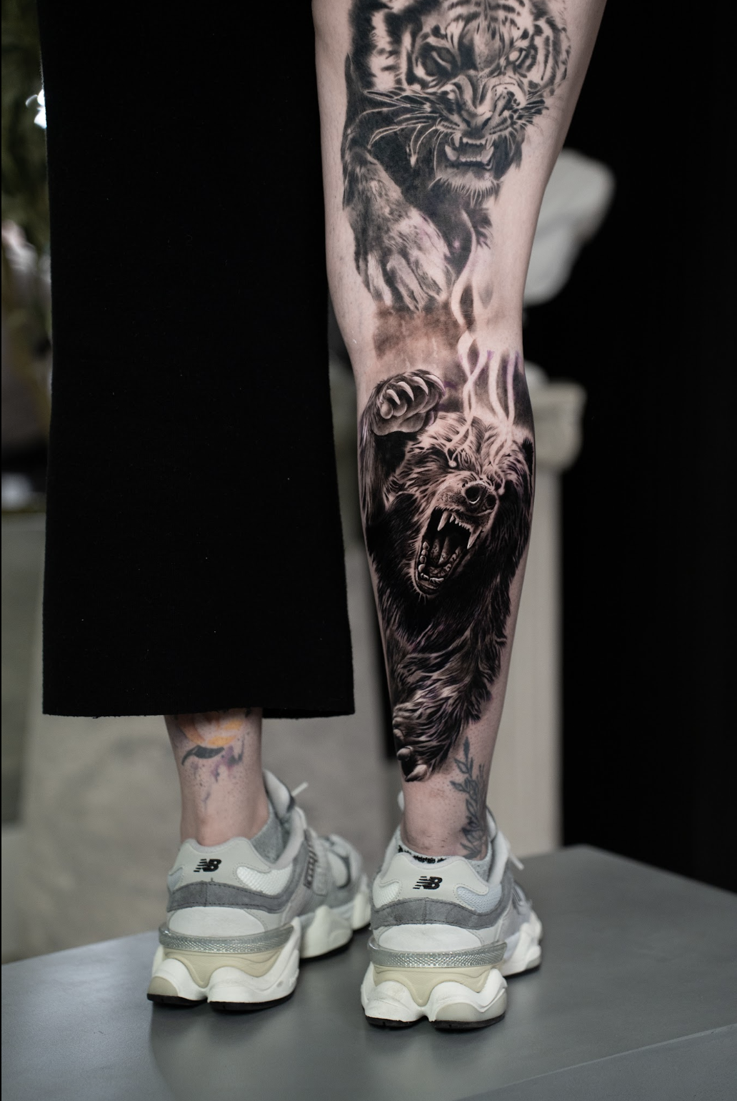 Black and grey realism leg sleeve tattoo by Luis Fernandez, Zen Tattoo Studio Oakville. Photorealistic wildlife piece featuring tiger and bear — large scale animal realism across full leg canvas. Serving Toronto and the GTA.