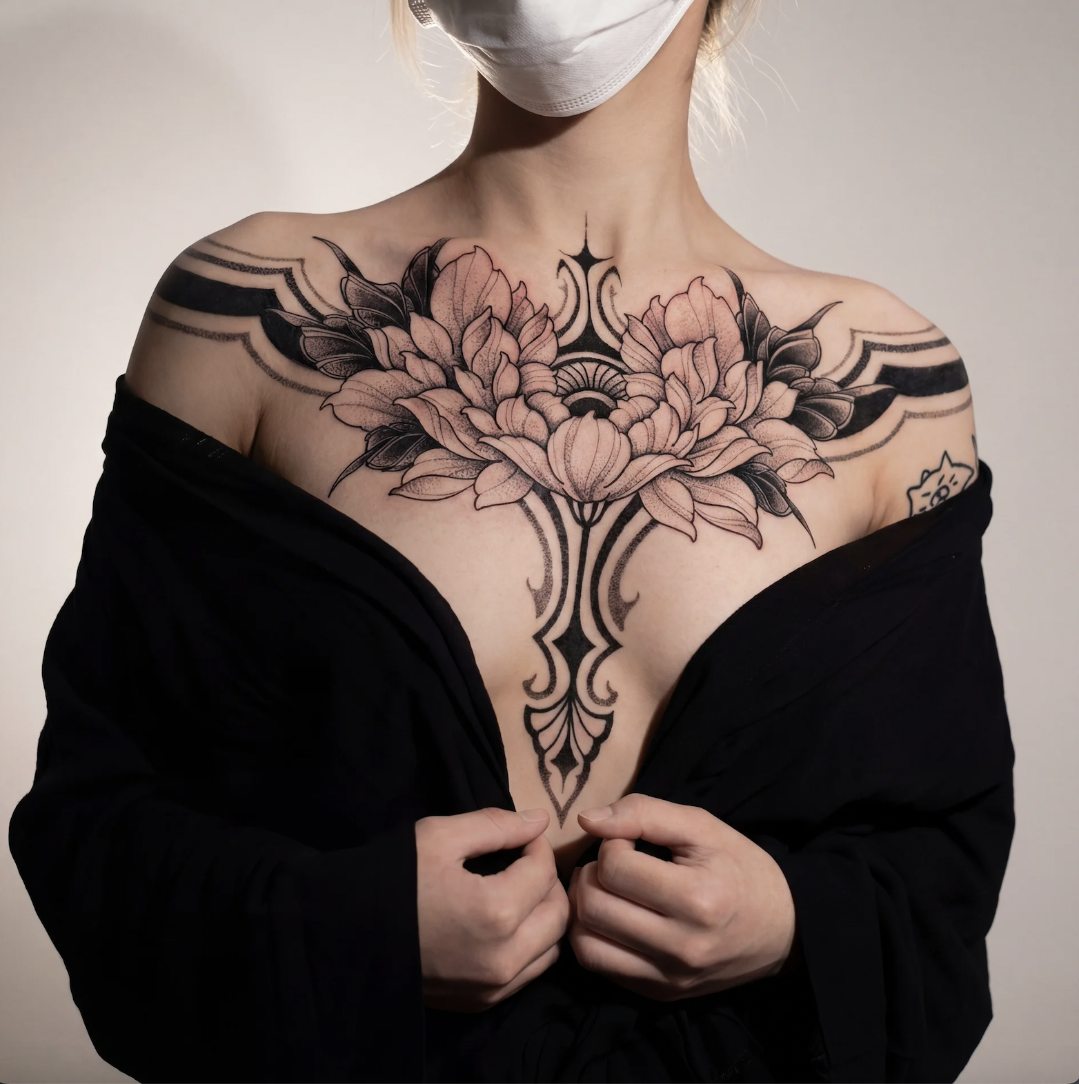 Female chest tattoo combining ornamental fine line details with floral elements for a luxury feminine look, Zen Tattoo Studio