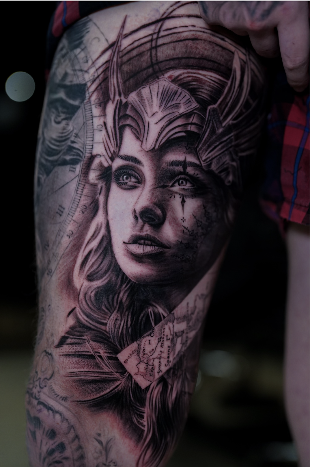 detailed leg tattoo of a woman with a helmet and map