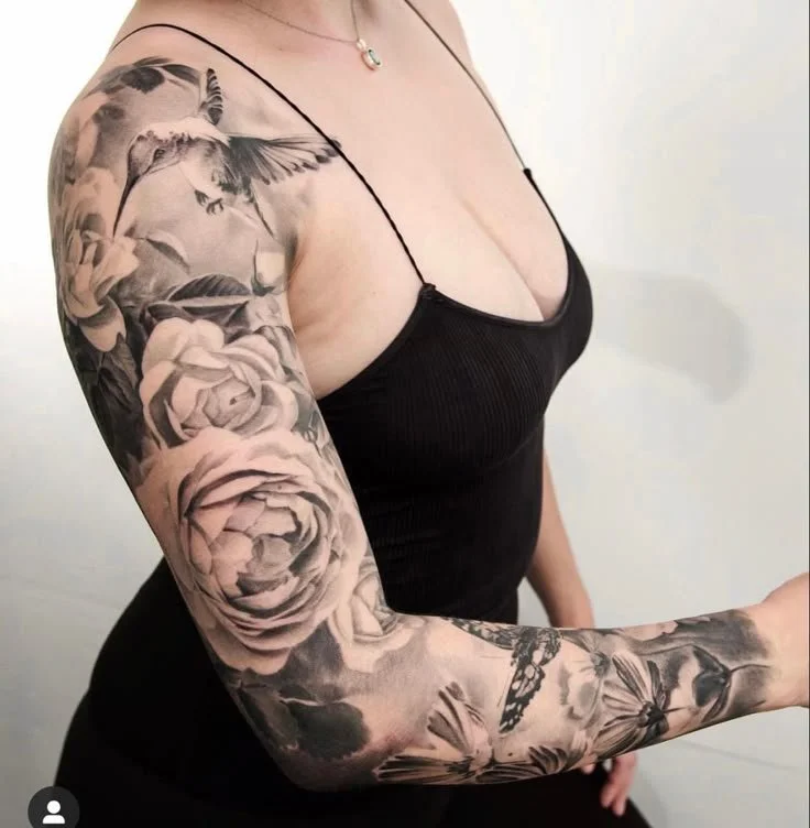 Black and grey realism floral sleeve with roses and hummingbird—premium tattoo sleeve ideas for women.