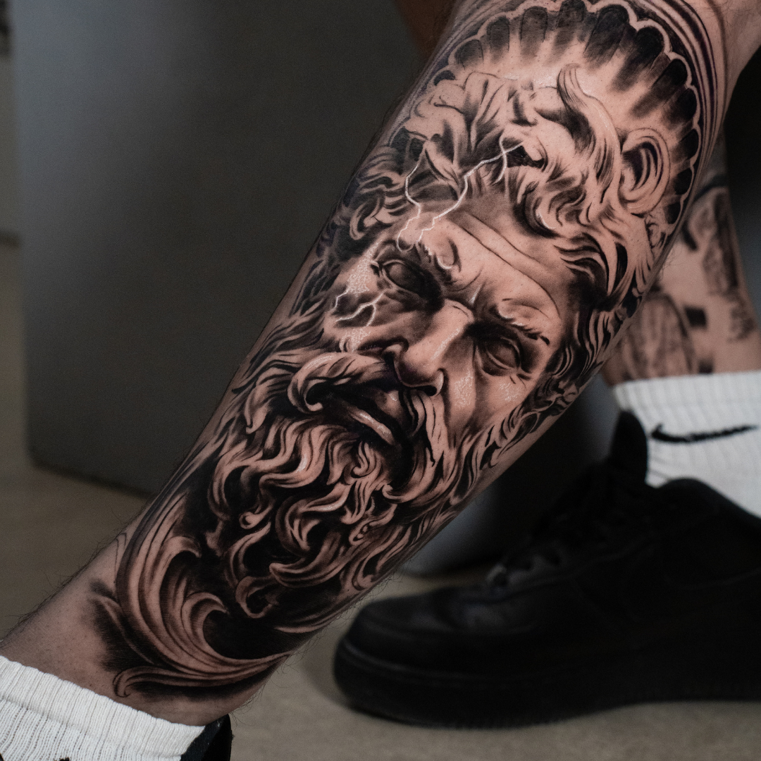 Black and grey realism tattoo of Zeus — large scale Greek mythology sleeve by Luis Fernandez at Zen Tattoo Studio, Oakville. Photorealistic portrait with sculptural detail and dramatic shading.