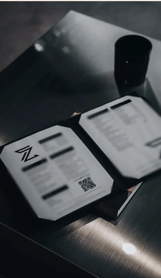 The Zen studio menu open on a steel table at Zen Tattoo Studio in Oakville, with a QR code for ordering from local Bronte restaurants.