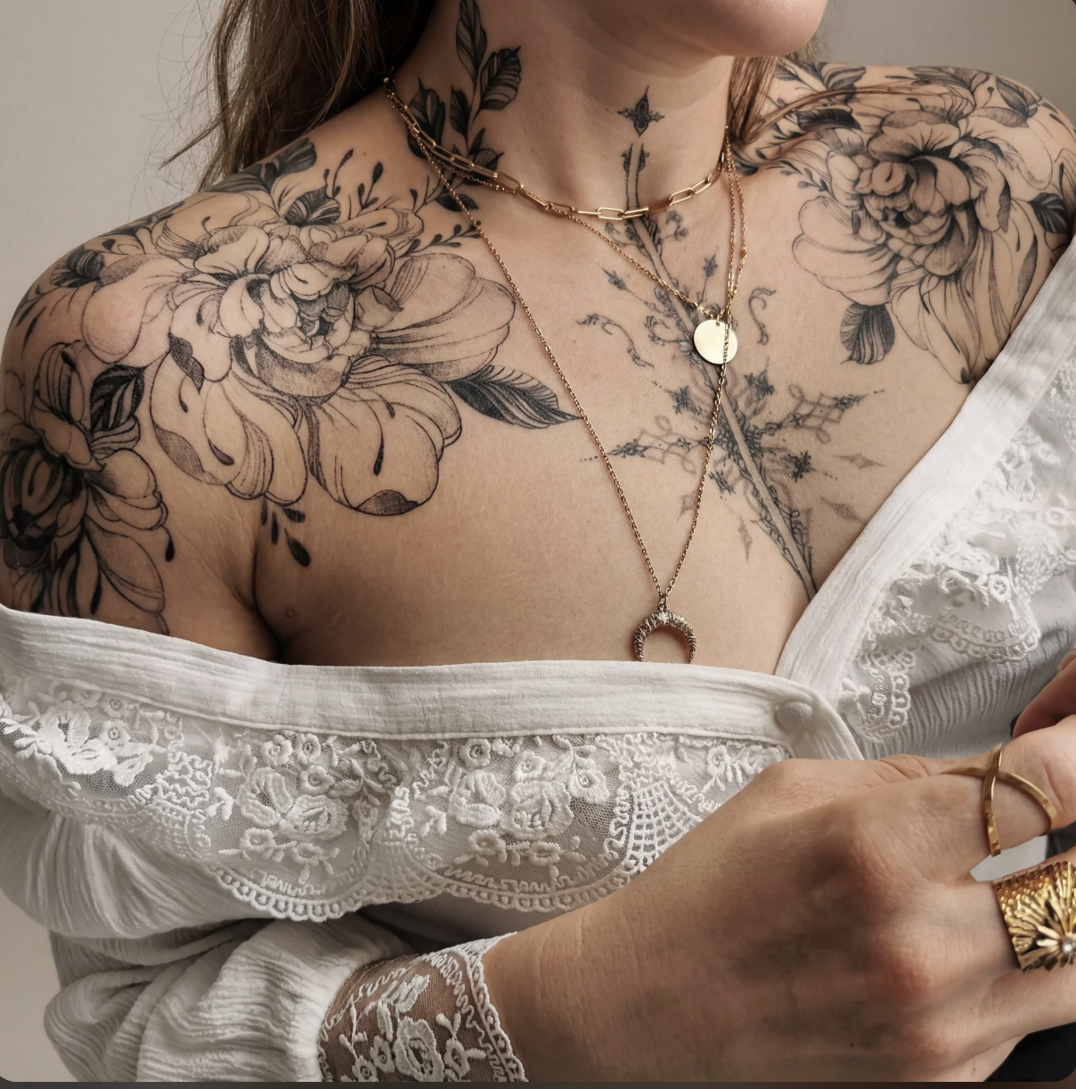 Fine line floral female chest tattoo flowing across sternum and collarbones in black and grey, Zen Tattoo Studio Toronto Oakville