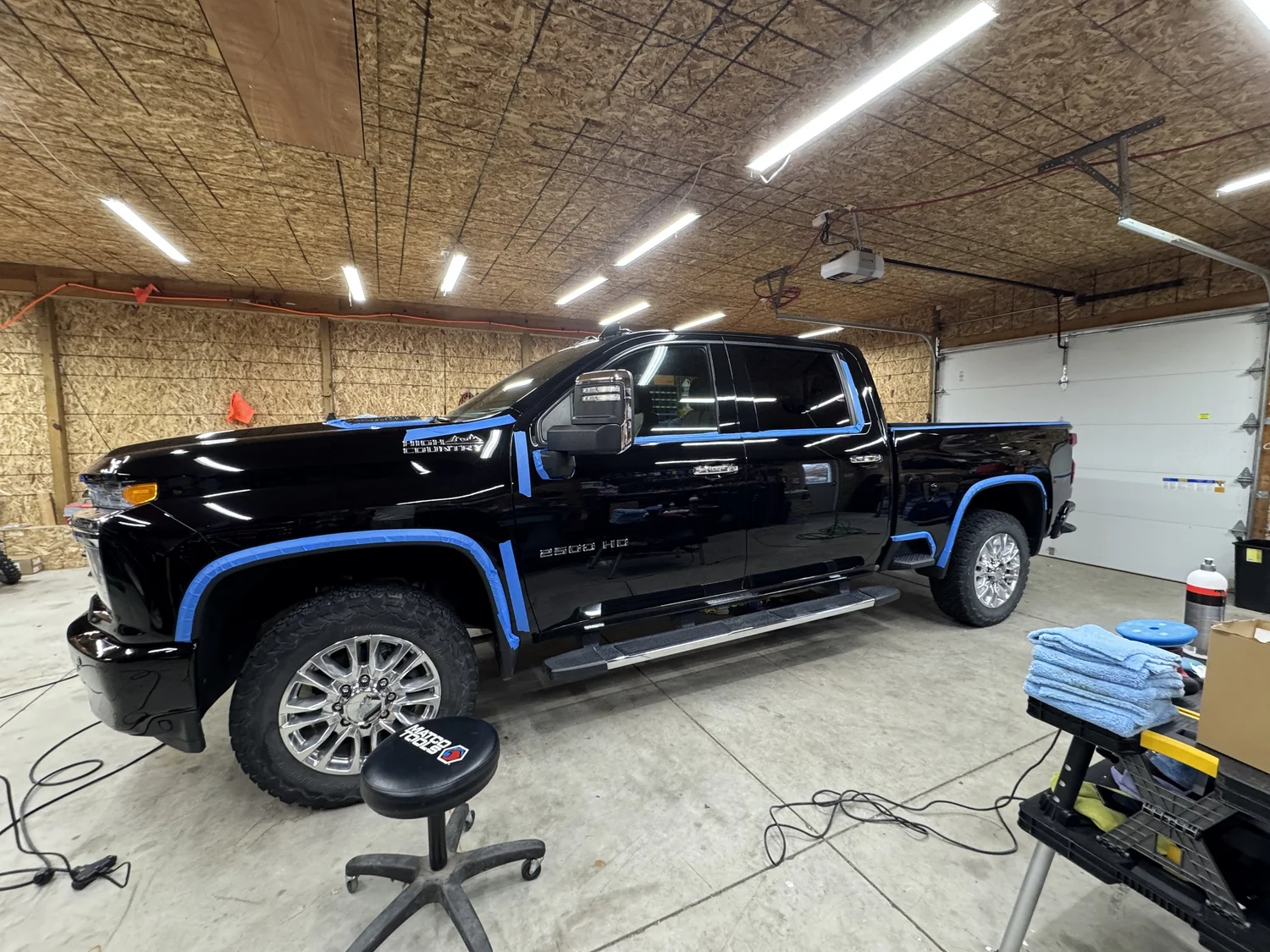 Black Chevy Silverado taped and prepped inside the LCB Auto Detailing shop in Howell, MI