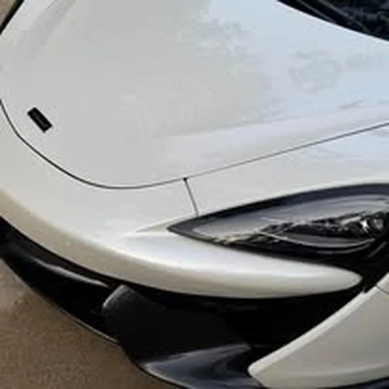 Glossy white hood with a mirror-like reflection after ceramic coating
