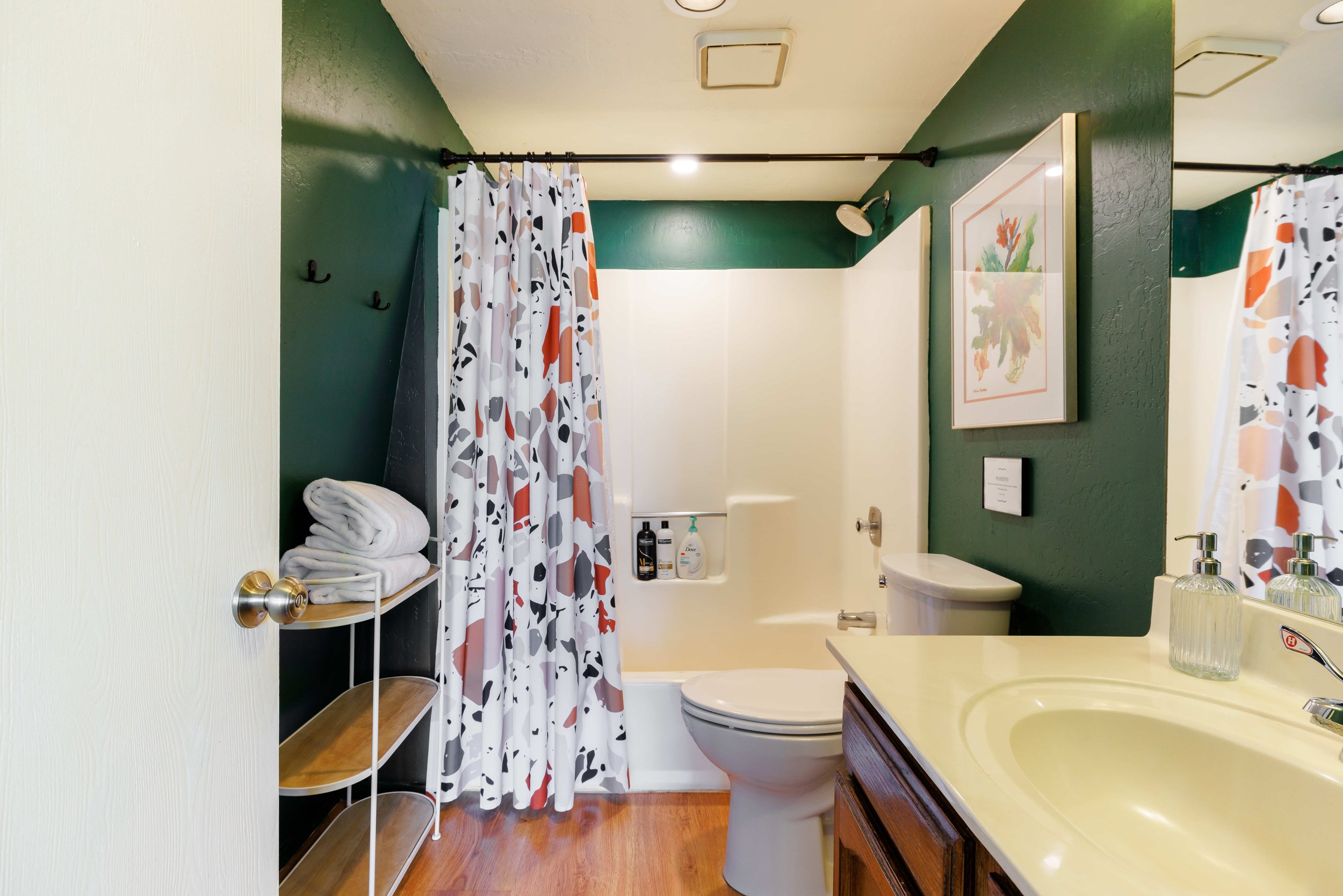 A fun green bathroom with a Terazzo shower curtain