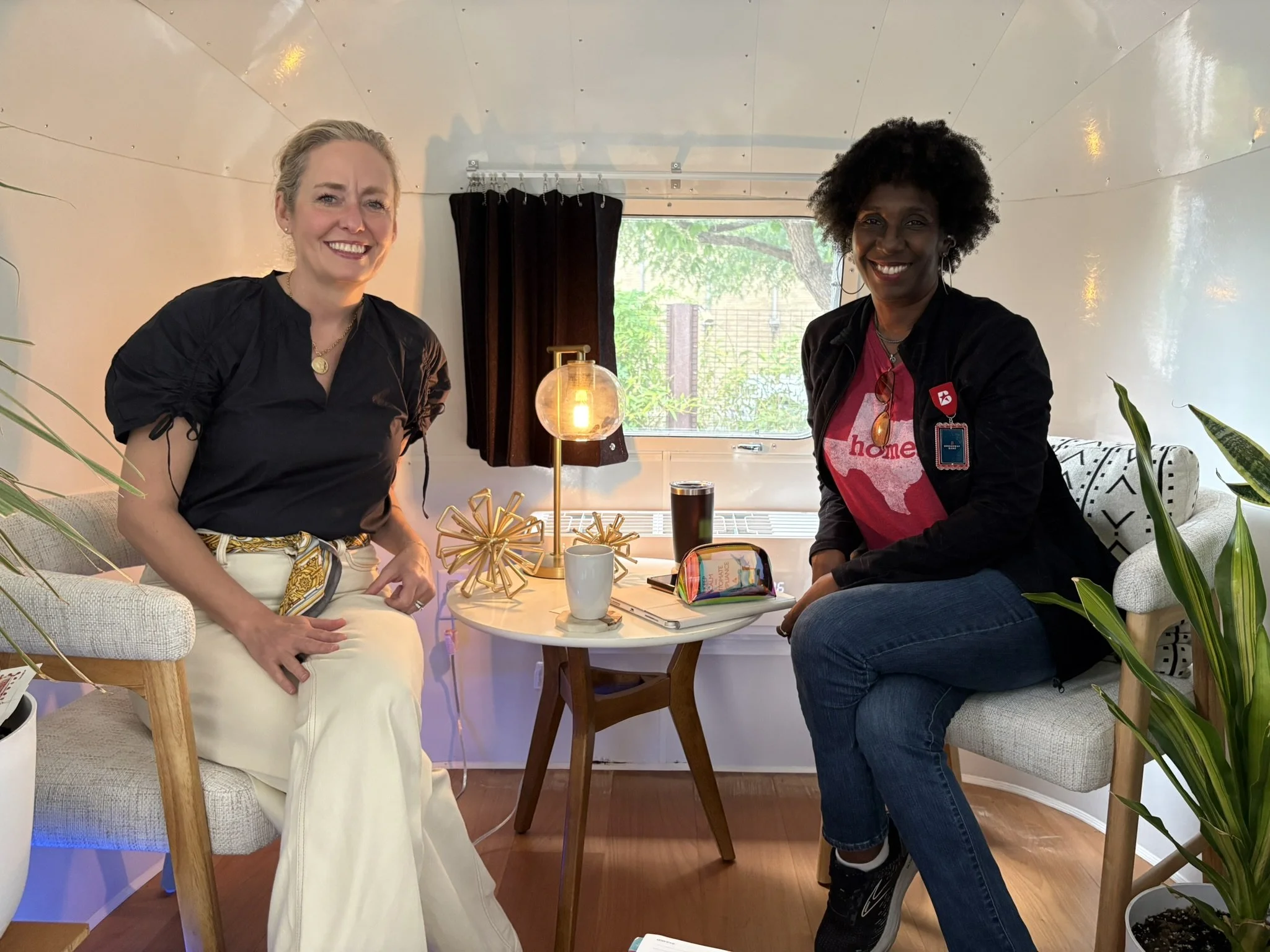 Two women recording a podcast in a renovated Airstream podcast studio in San Antonio