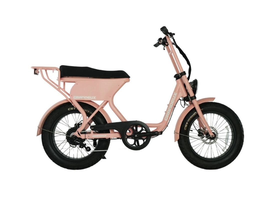 Vélo électrique rose avec panier à l'arrière et pneus tout-terrain.