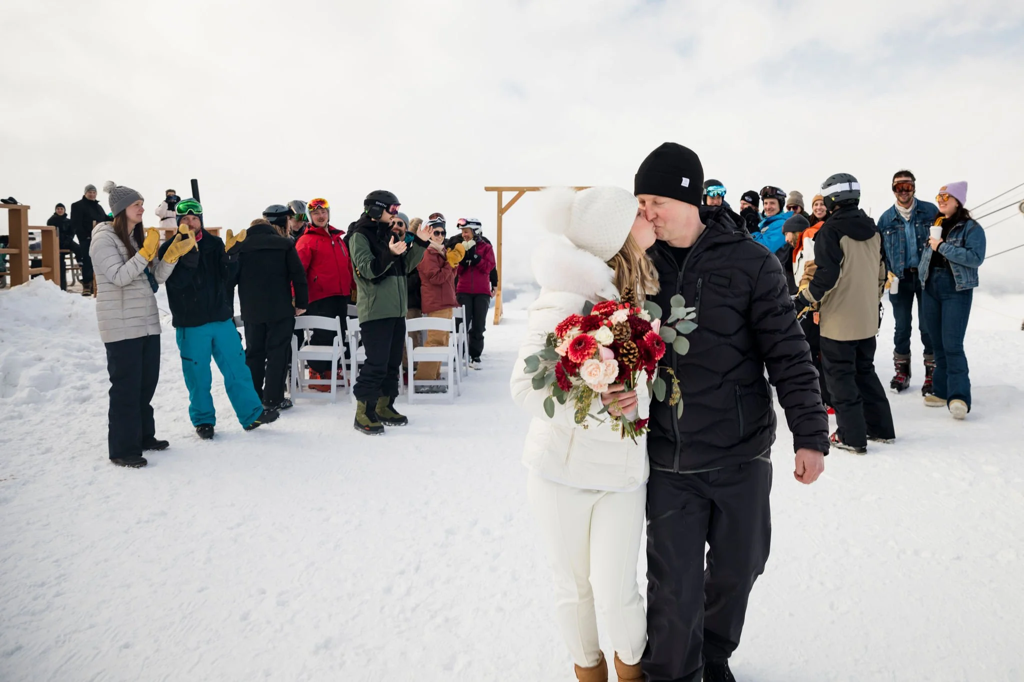 married couple kissing after walking down the aisle at winter wedding