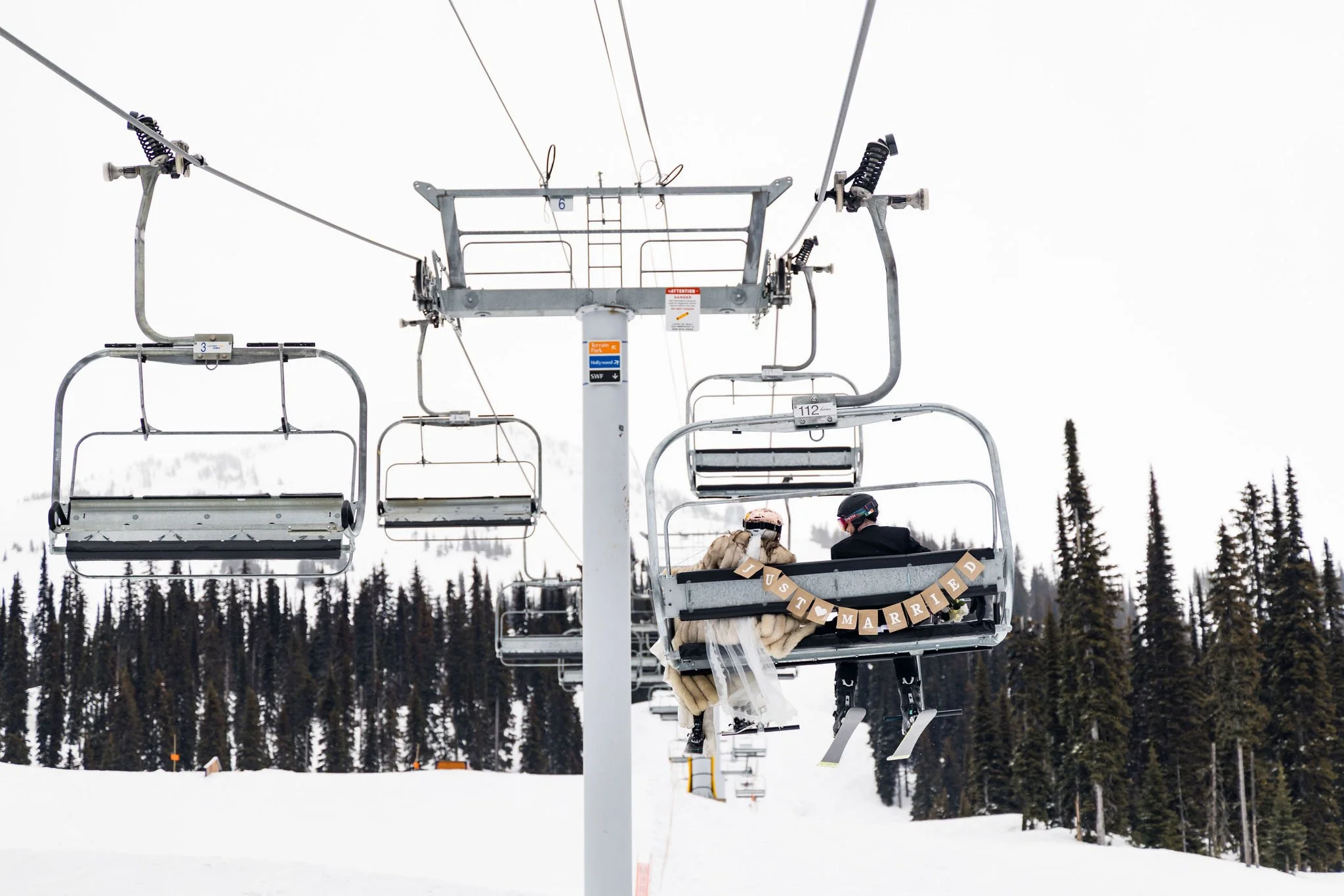 wedding couple on chairlift with just married sign