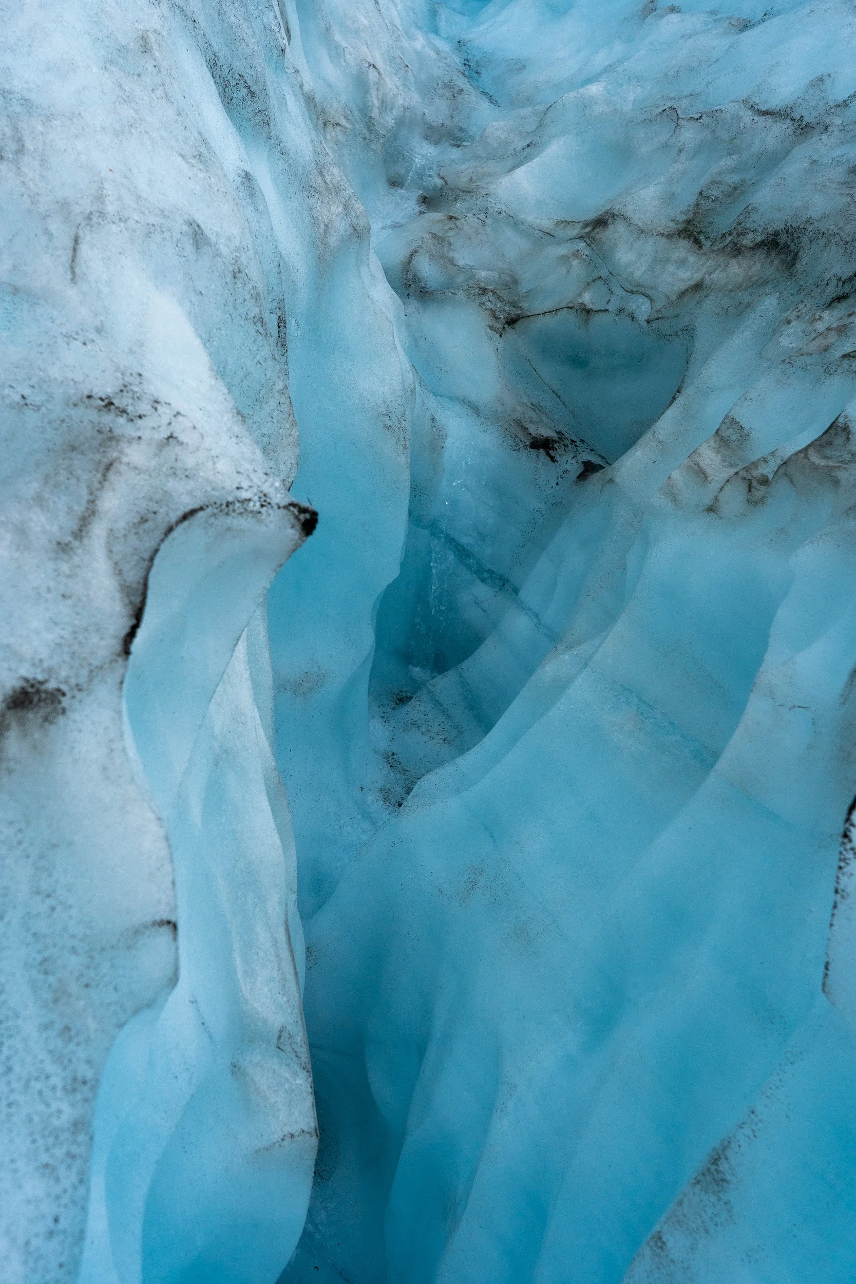 Wolverine Glacier. Glacier ice is blue because the red (long wavelength) part of white light is absorbed by the ice and the blue (short wavelength) light is transmitted and scattered. The longer the light path travels in ice and the more dense the ic
