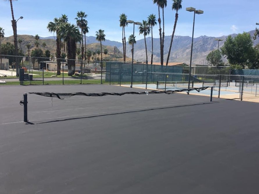  A resurfaced tennis court drying before it gets painted to turn it into a pickleball court 