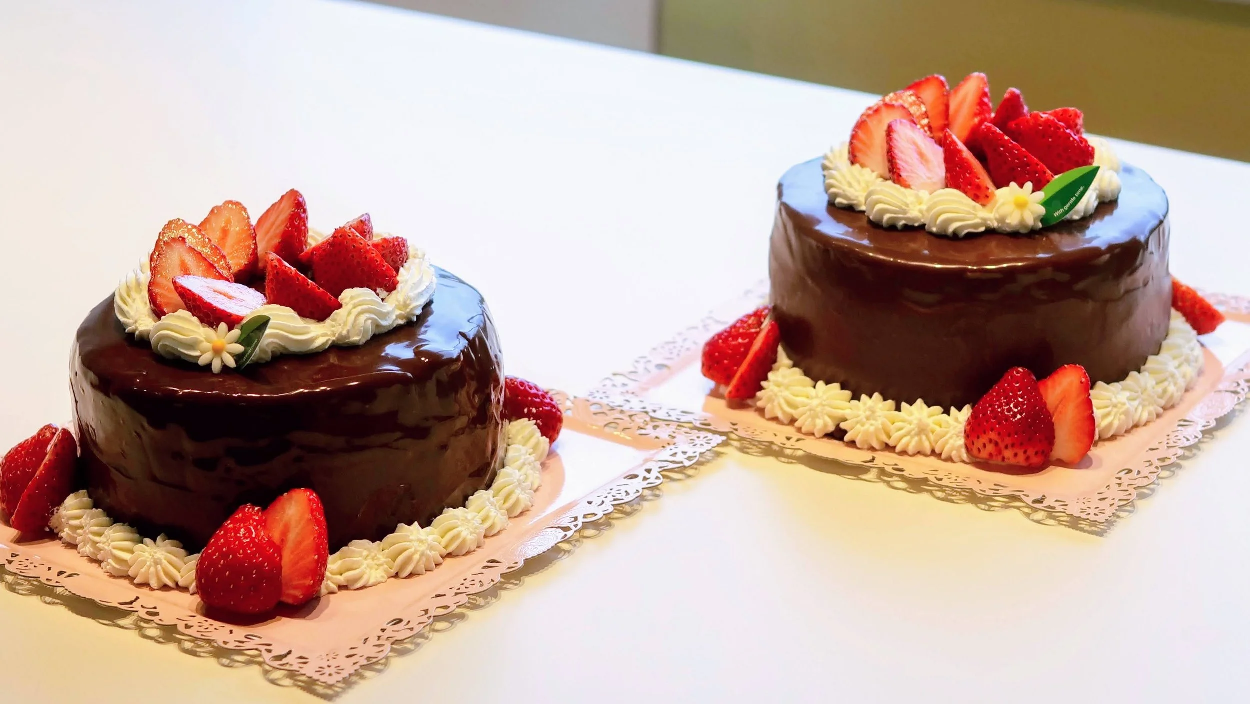 パティスリー301で作られた、艶やかなチョコレートガナッシュといちごが美しいデコレーションケーキが2つテーブルの上に並んでいる。