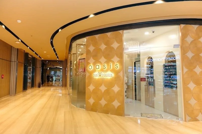 Front entrance of Nail Tropics, a nail salon, with glass doors and a well-lit interior.