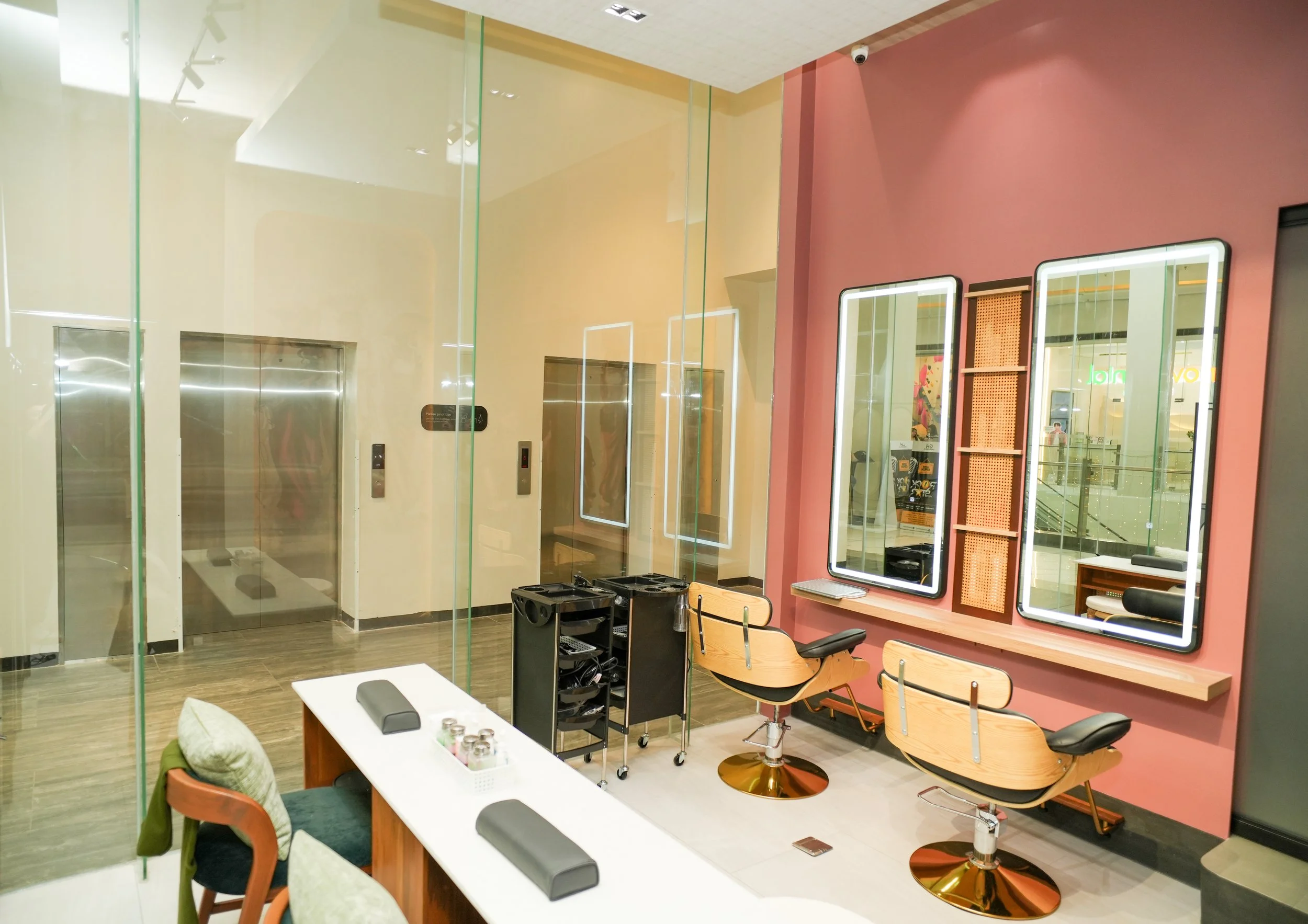 Customer receiving a spa relaxation with light-colored reclining chairs, beige cushions, and footstools. The walls feature decorative art resembling coral.