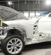 Auto manufacturing plant with a white car under assembly.