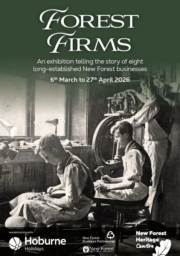 Person sitting beside a rock cairn on a rocky mountain landscape, with hills and cloudy sky in the background.