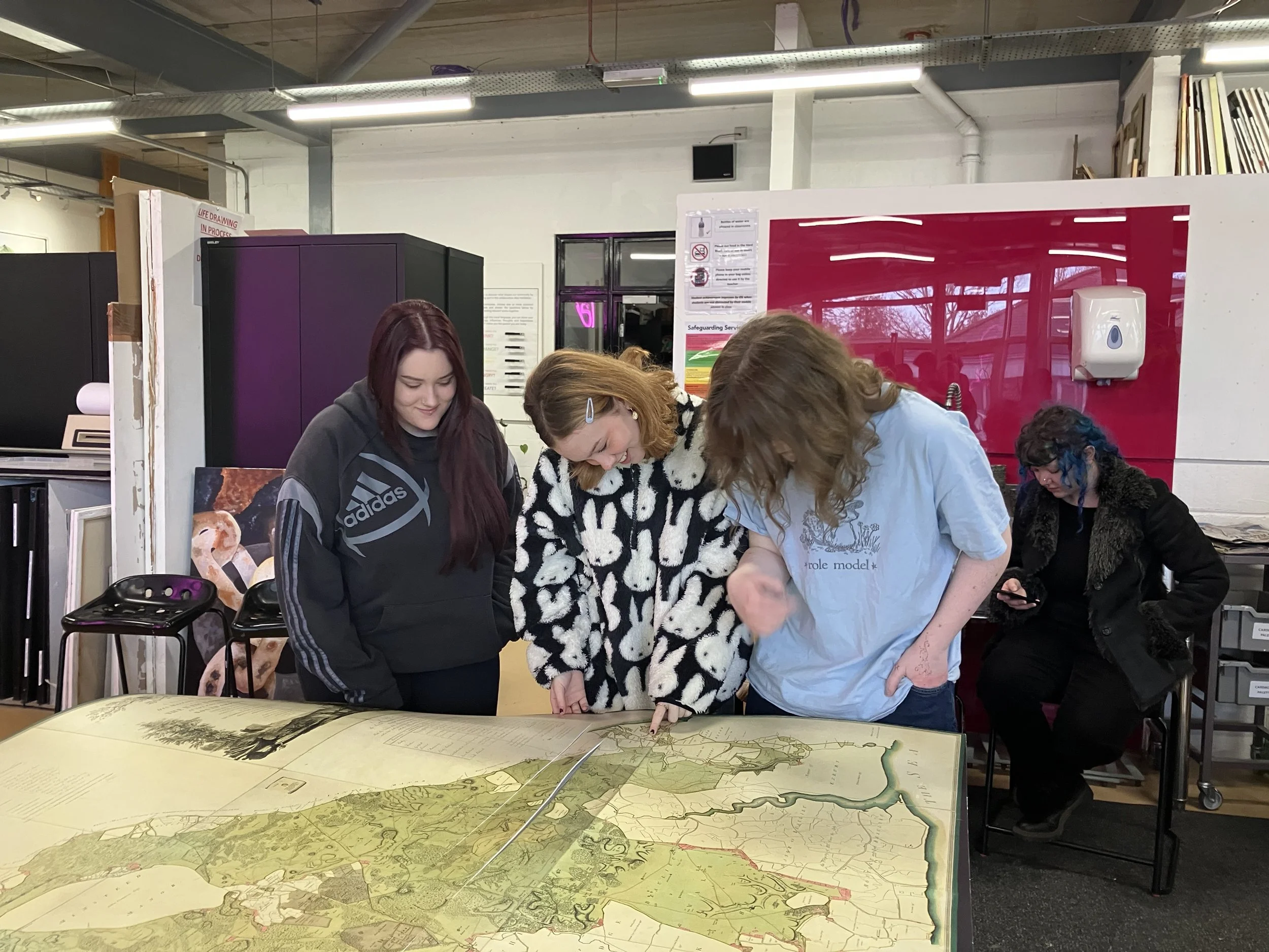Group of teenage students looking at a map on a table