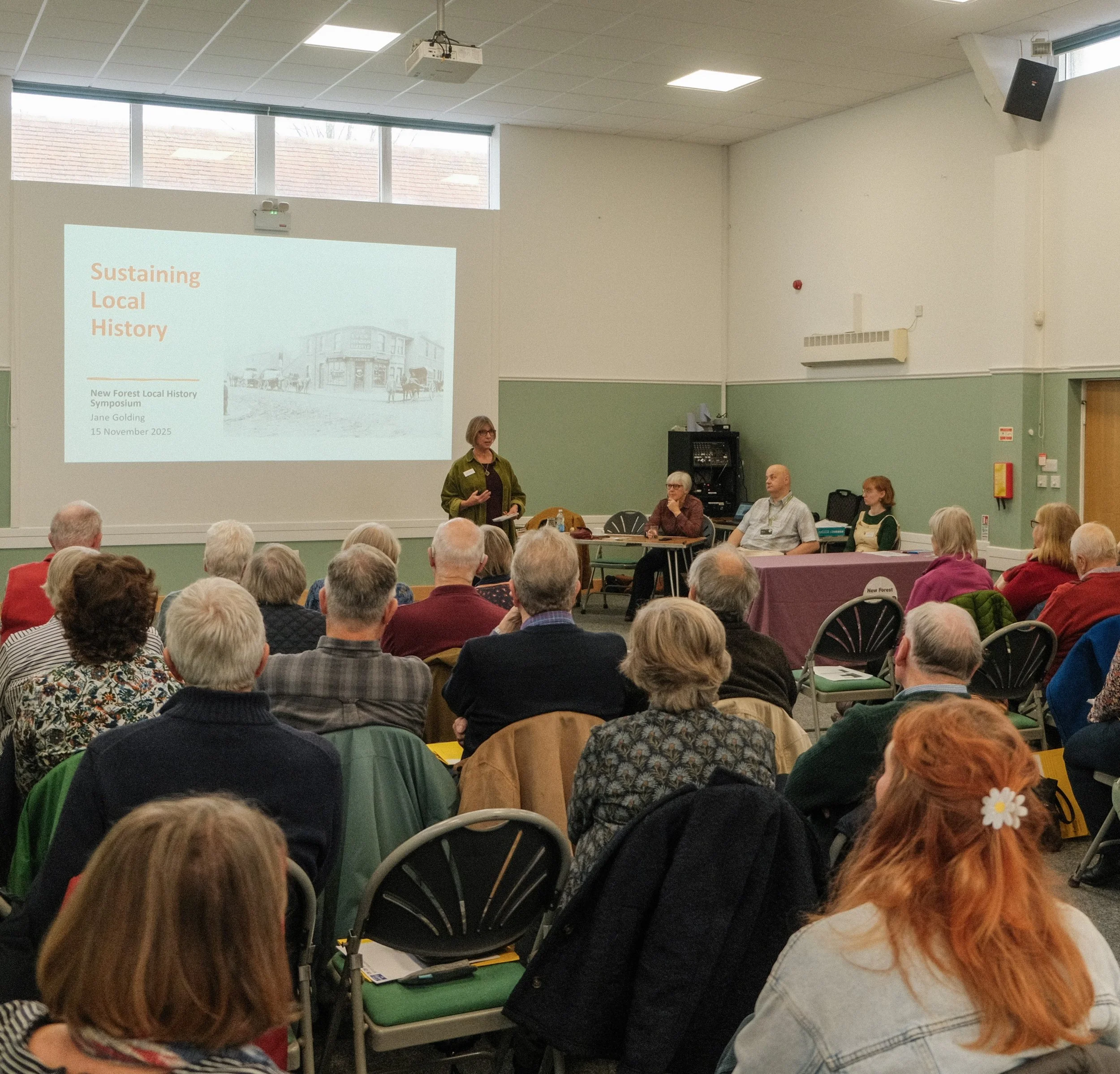 A group of people sat in a village hall listening to a local history talk