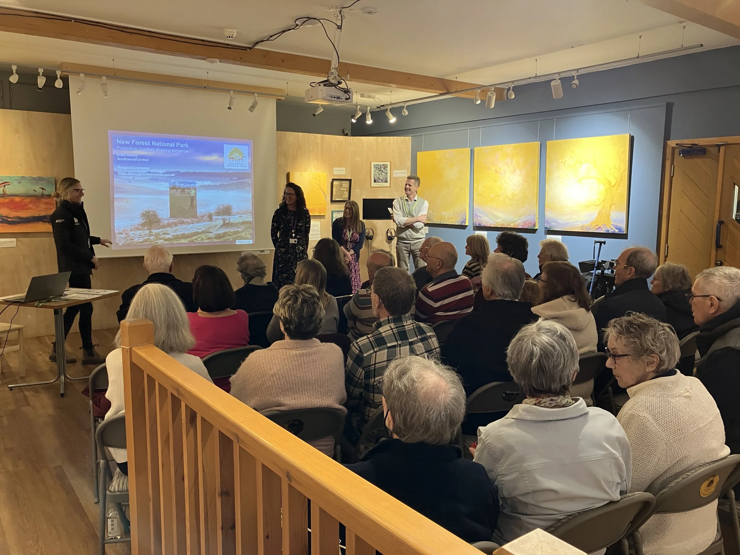 Group of older people sat listening to a talk with a powerpoint