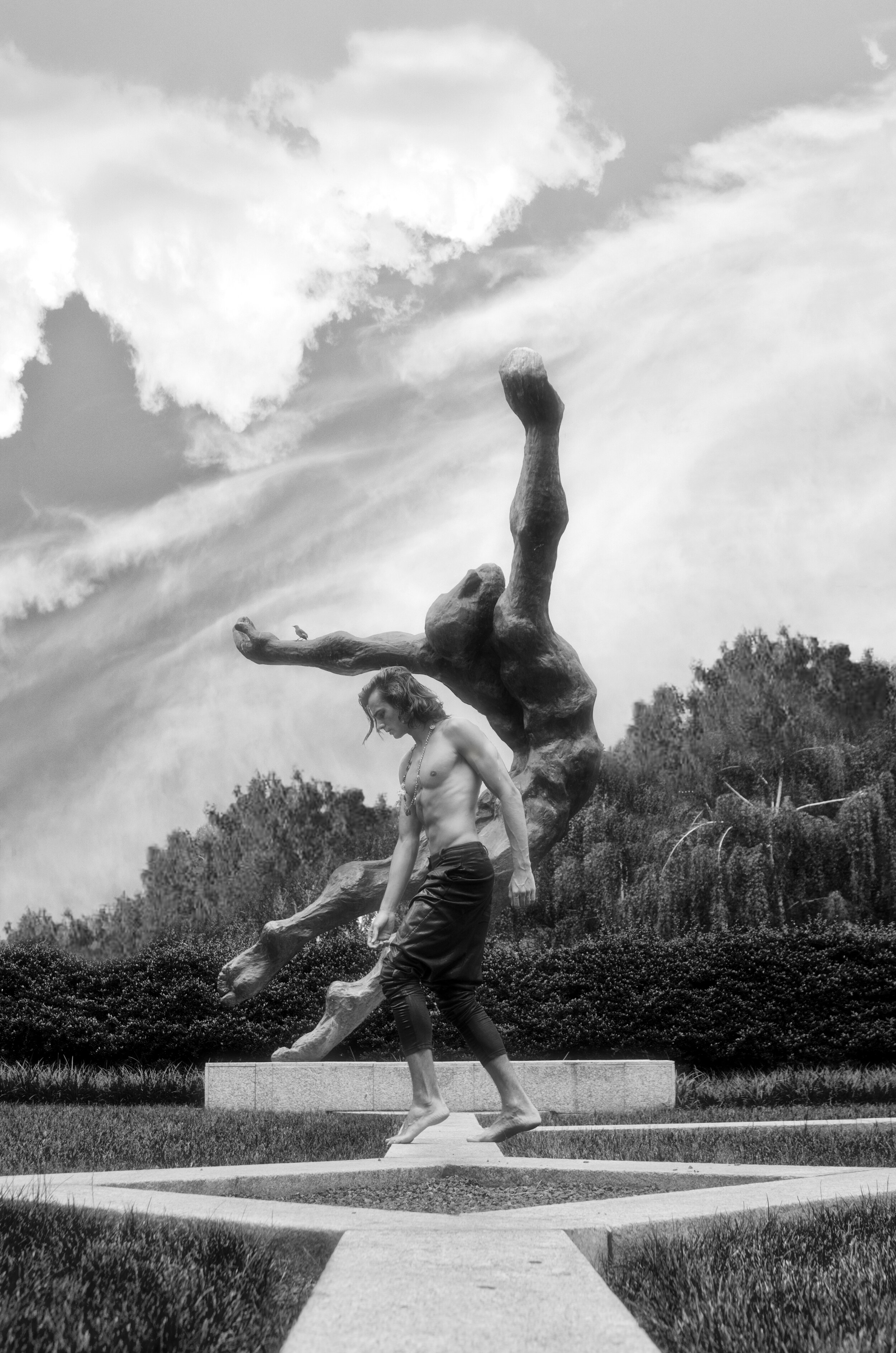 fine art print of man standing near a statue outside