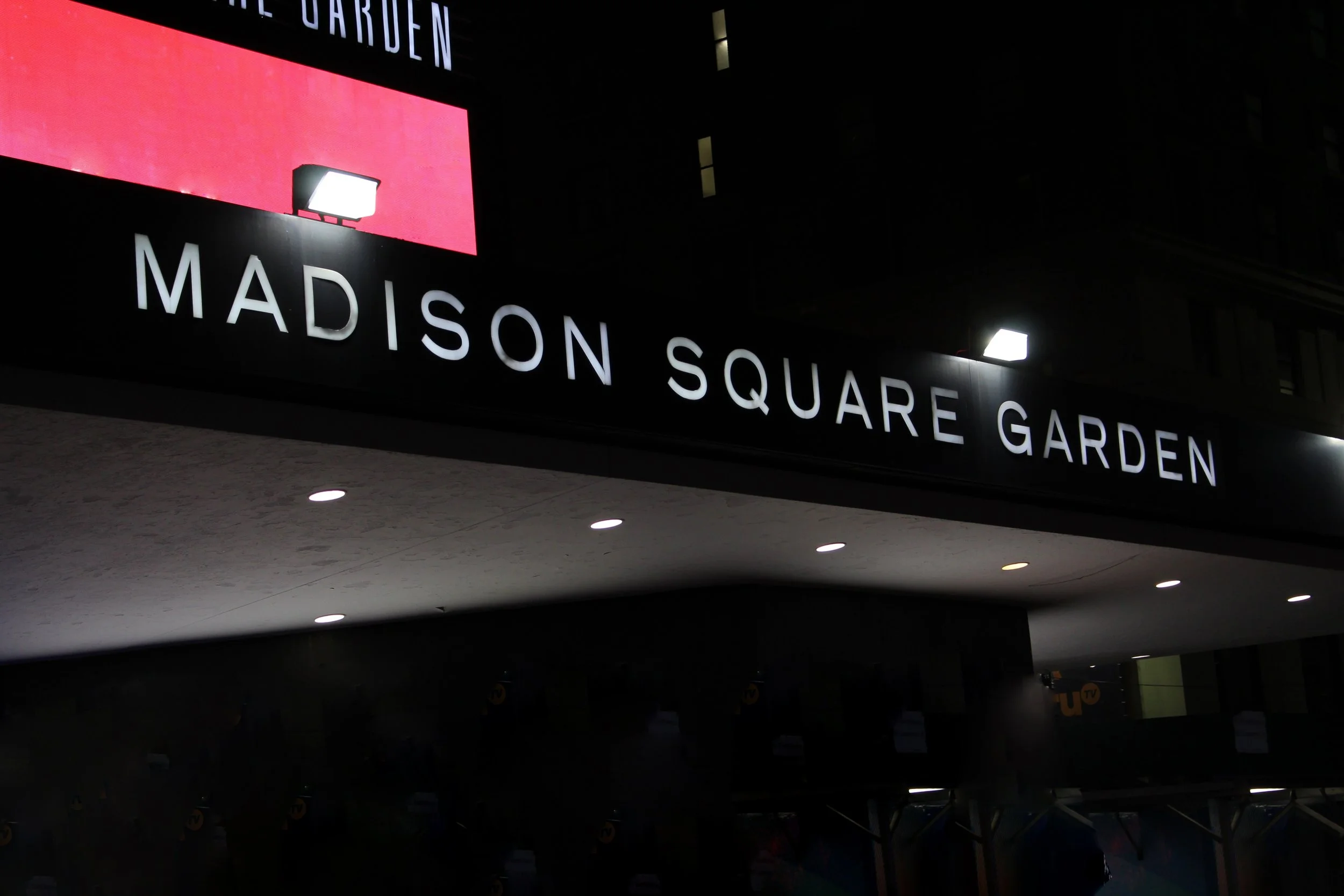 Madison Square Garden entrance sign illuminated at night.