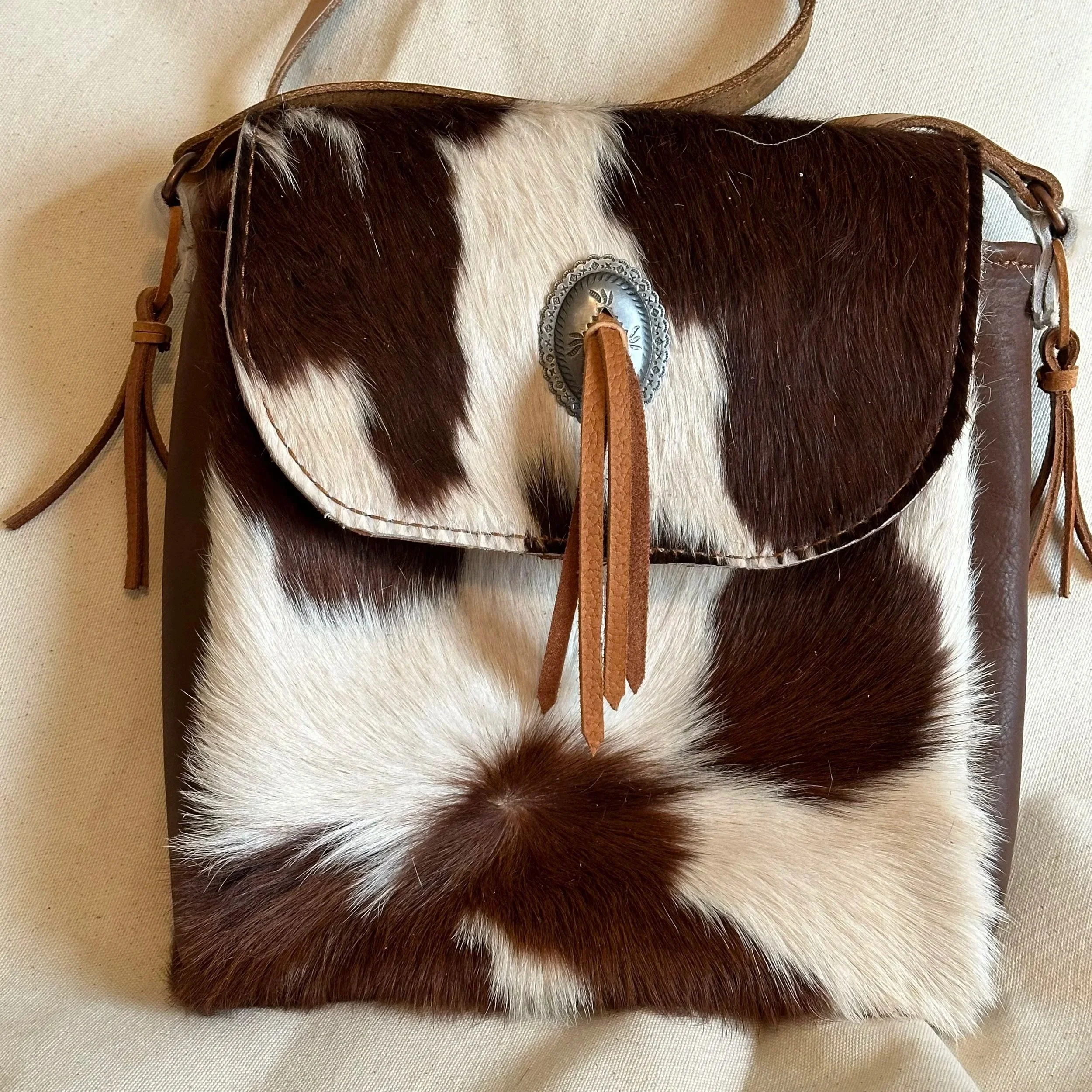 SOLD:  Cowhide front and back with leather sides; lined with pocket. 13"x13" (Custom order only)