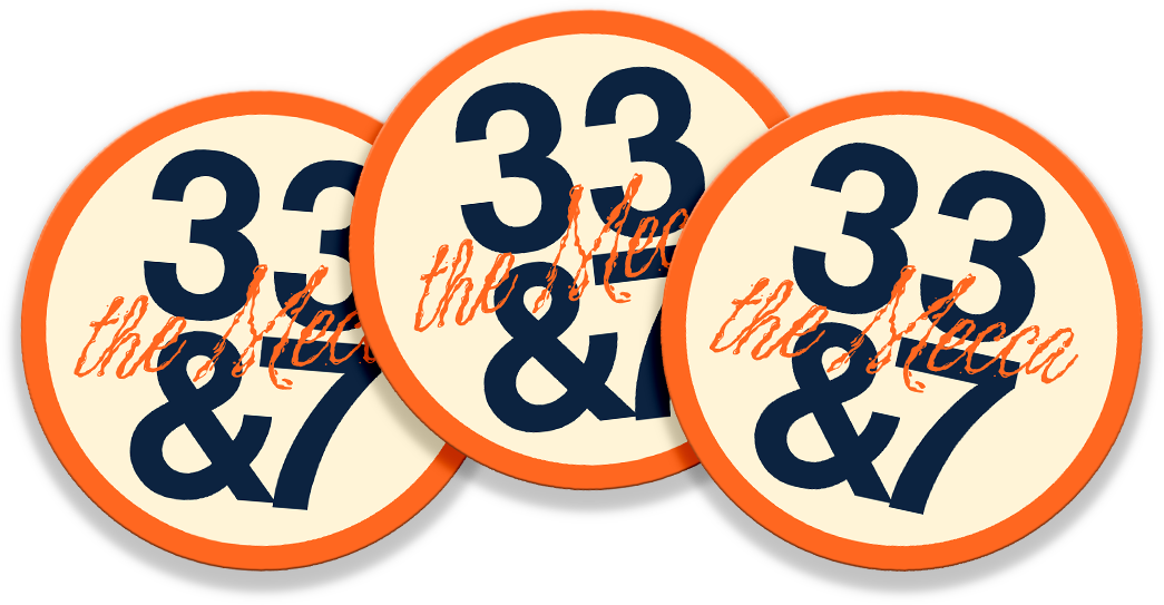 Three "33 & 7" circular vinyl stickers arranged together, showing the bold navy numerals and orange "the Mecca" script design.