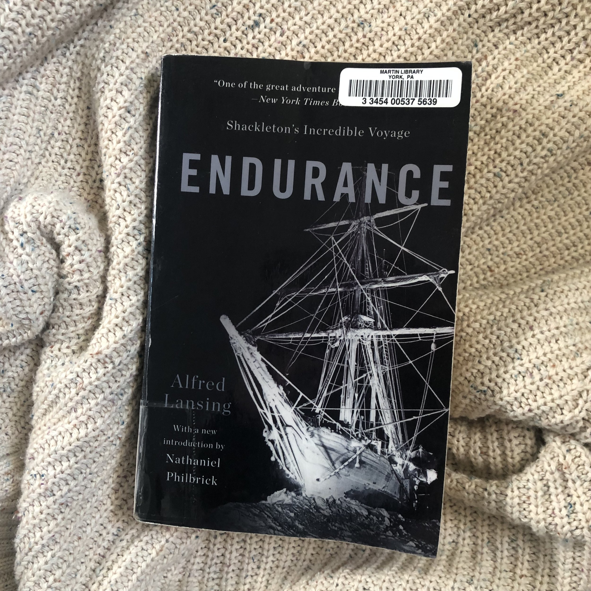 The book Endurance by Alfred Lansing laying on a sweater