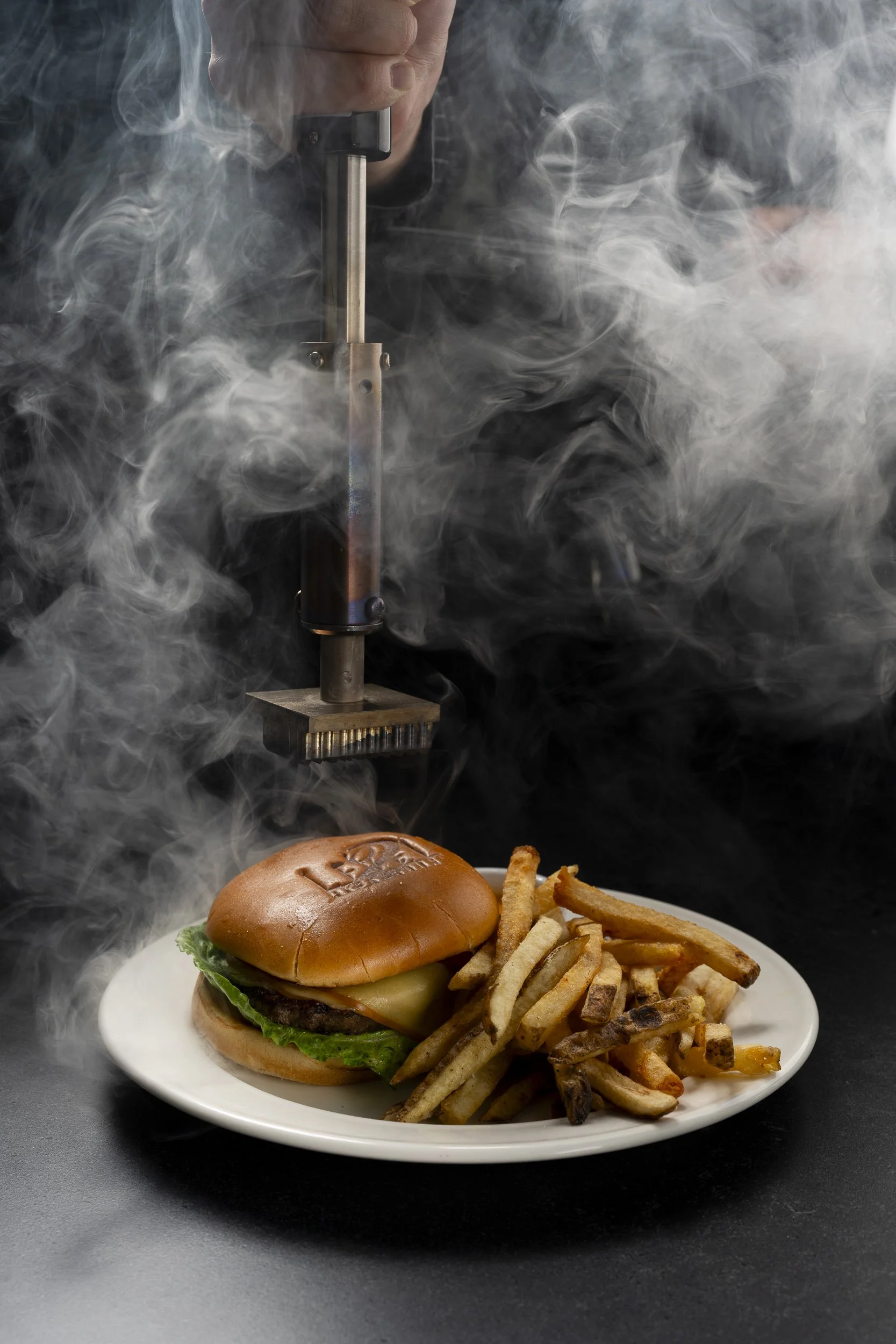 A plate with a cheeseburger, French fries, and sweet potato fries, with steam rising from the food and a thermal laser resembling a laser gun above.
